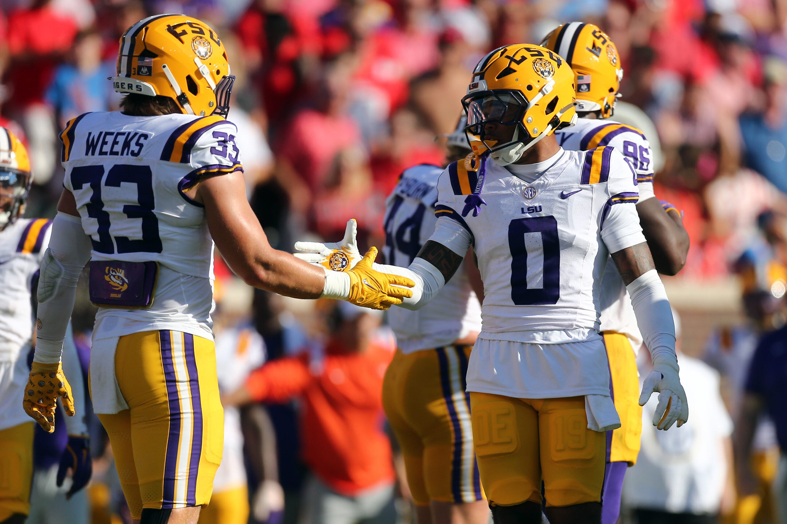 Sep 27, 2025; Oxford, Mississippi, USA; LSU Tigers linebacker West Weeks (33) and safety Tamarcus Cooley (0) react after a defensive stop during the second quarter against the Mississippi Rebels at Vaught-Hemingway Stadium.