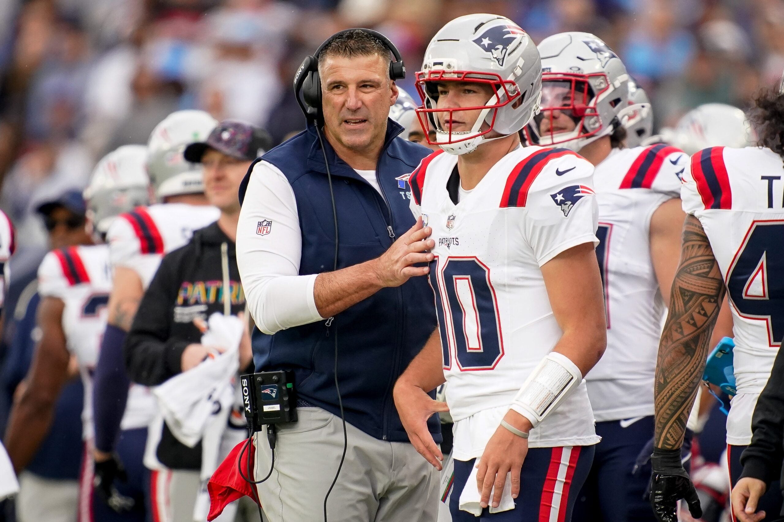 New England Patriots coach Mike Vrabel talks to quarterback Drake Maye (10) during the second quarter at Nissan Stadium in Nashville, Tenn., Sunday, Oct. 19, 2025.