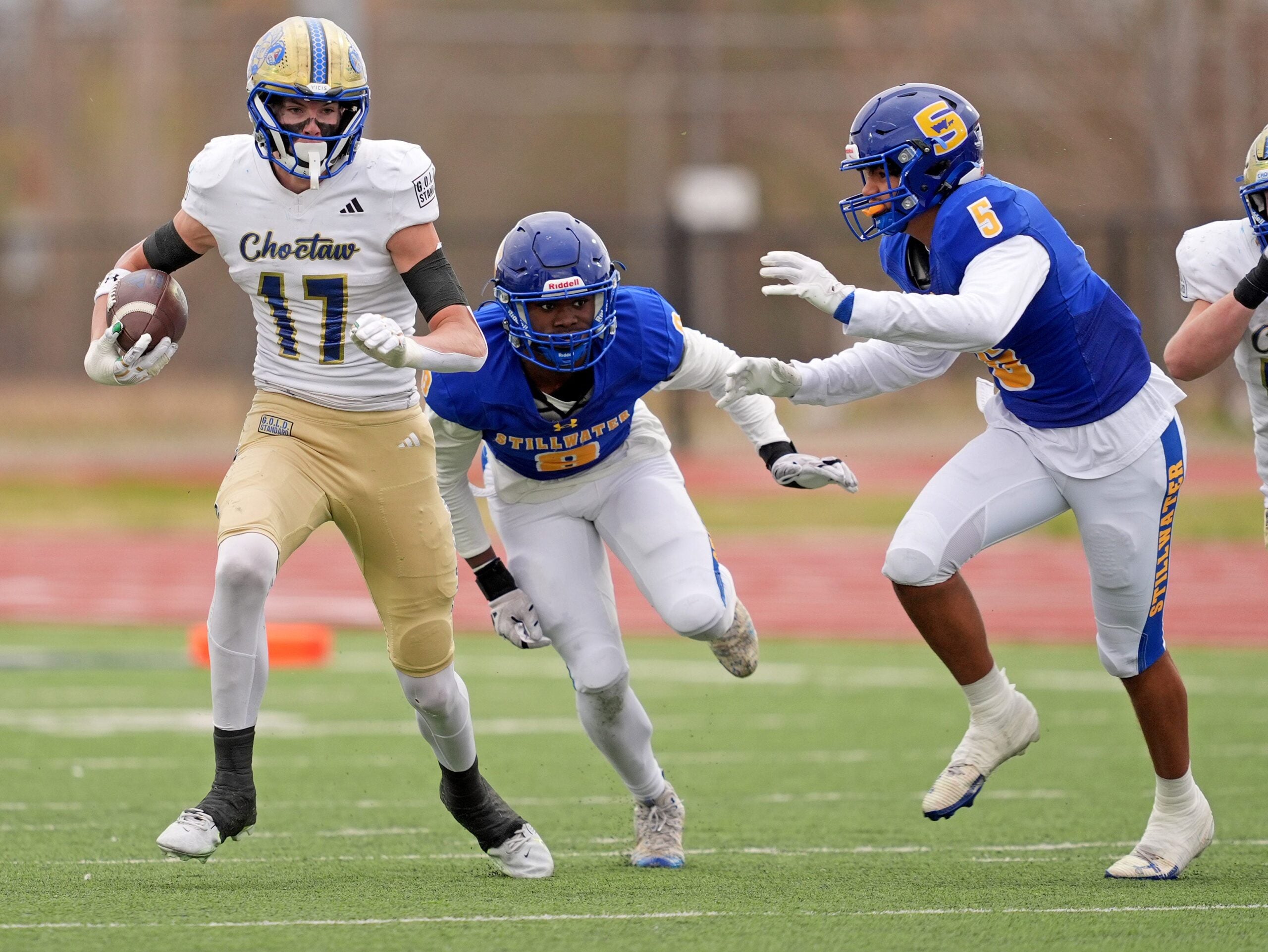 Choctaw's Titus Hawk runs after a catch as Stillwater's Brandon Mitchell (8) and Braylen Taylor (5) defend during the Class 6A II semifinal playoff game between Choctaw and Stillwater at Edmond North High School in Edmond, Okla., Friday Nov. 28, 2025.