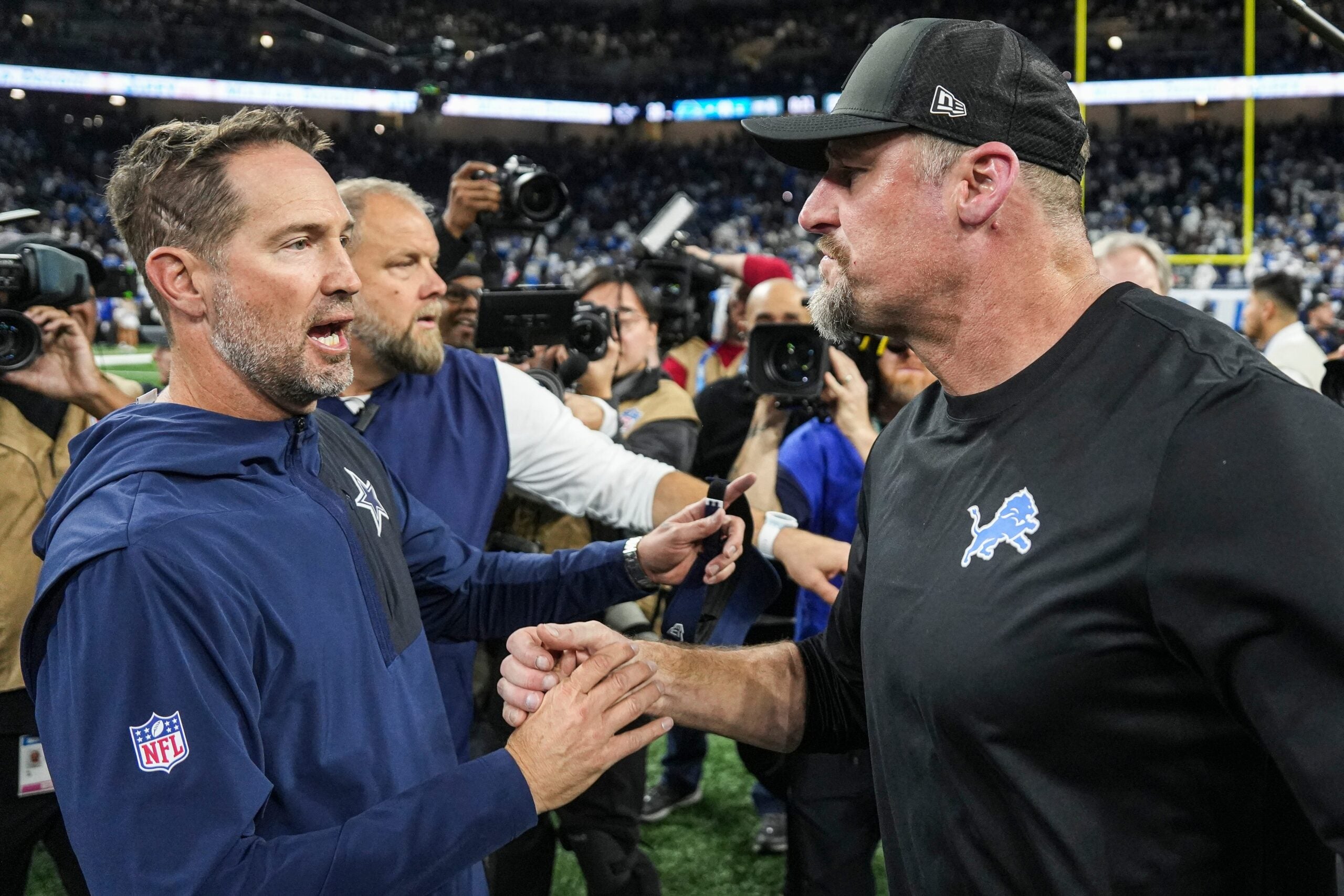 Detroit Lions head coach Dan Campbell shakes hands with Dallas Cowboys head coach Brian Schottenheimer after 44-30 win at Ford Field in Detroit on Thursday, Dec. 4, 2025.