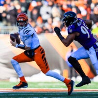 Dec 14, 2025; Cincinnati, Ohio, USA; Cincinnati Bengals quarterback Joe Burrow (9) runs with the ball against Baltimore Ravens linebacker Tavius Robinson (95) in the first half at Paycor Stadium.