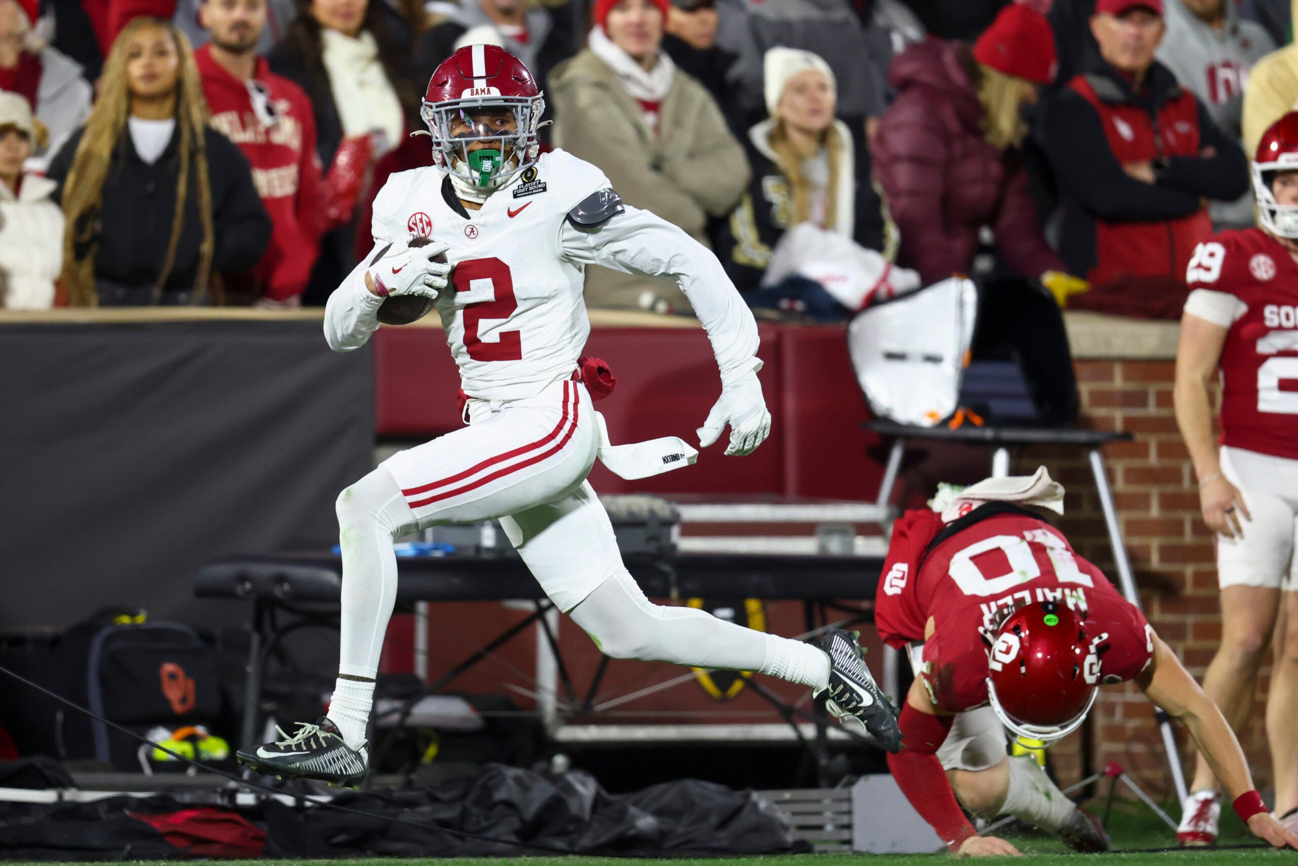 Dec 19, 2025; Norman, OK, USA; Alabama Crimson Tide defensive back Zabien Brown (2) eludes a tackle by Oklahoma Sooners quarterback John Mateer (10) in the first half at Gaylord Family OK Memorial Stadium.