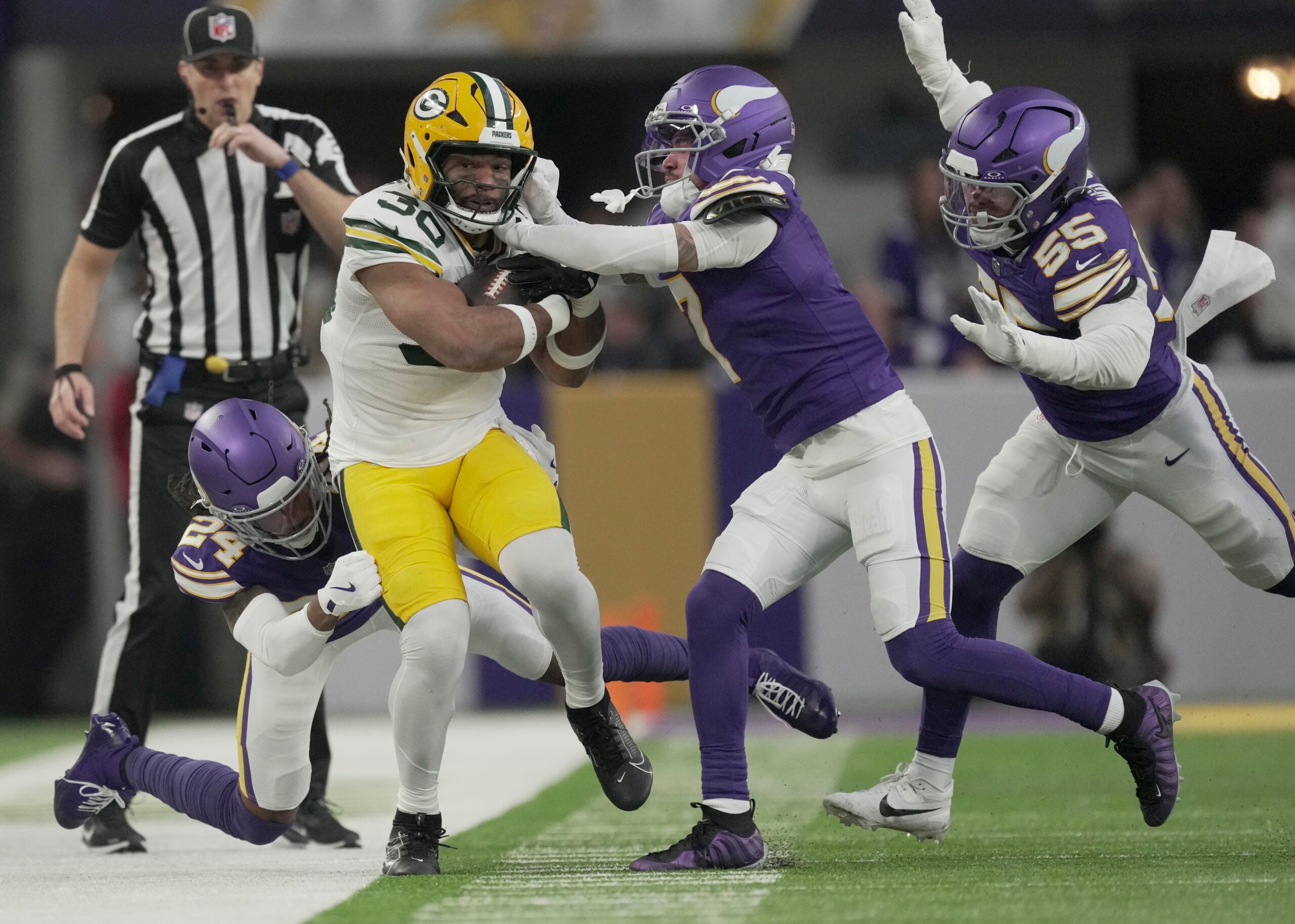 Jan 4, 2026; Minneapolis, Minnesota, USA; Green Bay Packers running back Chris Brooks (30) is shoved out of bounds by Minnesota Vikings safety Jay Ward (24) and cornerback Byron Murphy Jr. (7) during the second quarter at U.S. Bank Stadium.