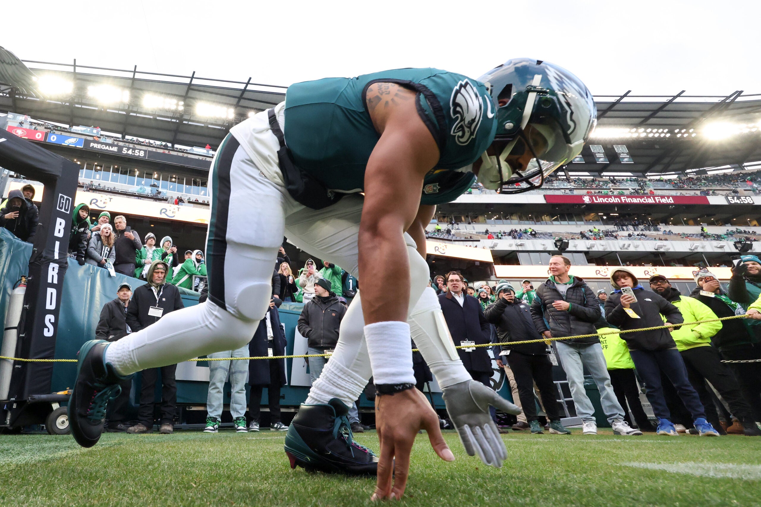 Jan 11, 2026; Philadelphia, PA, USA; Philadelphia Eagles quarterback Jalen Hurts (1) touches the grass as he heads out to the field for warmups prior to an NFC Wild Card Round game against the San Francisco 49ers at Lincoln Financial Field.