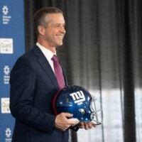 New Giants Head Coach John Harbaugh holds up a New York Giants helmet during a press conference welcoming Harbaugh at the Quest Diagnostics Training Center in East Rutherford on Tuesday, Jan. 20, 2025.