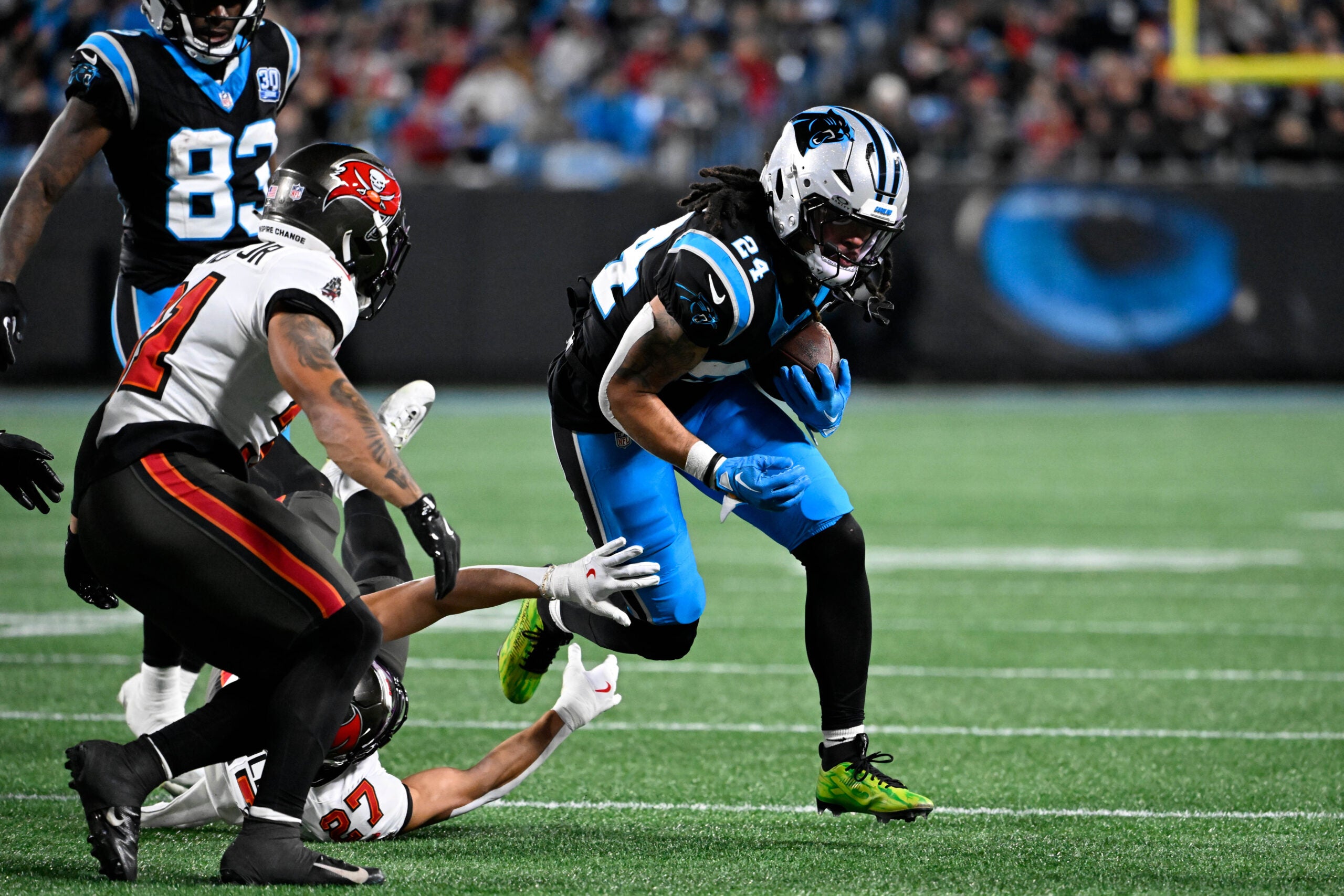 Dec 1, 2024; Charlotte, North Carolina, USA; Carolina Panthers running back Jonathon Brooks (24) runs as Tampa Bay Buccaneers cornerback Zyon McCollum (27) defends in the third quarter at Bank of America Stadium.
