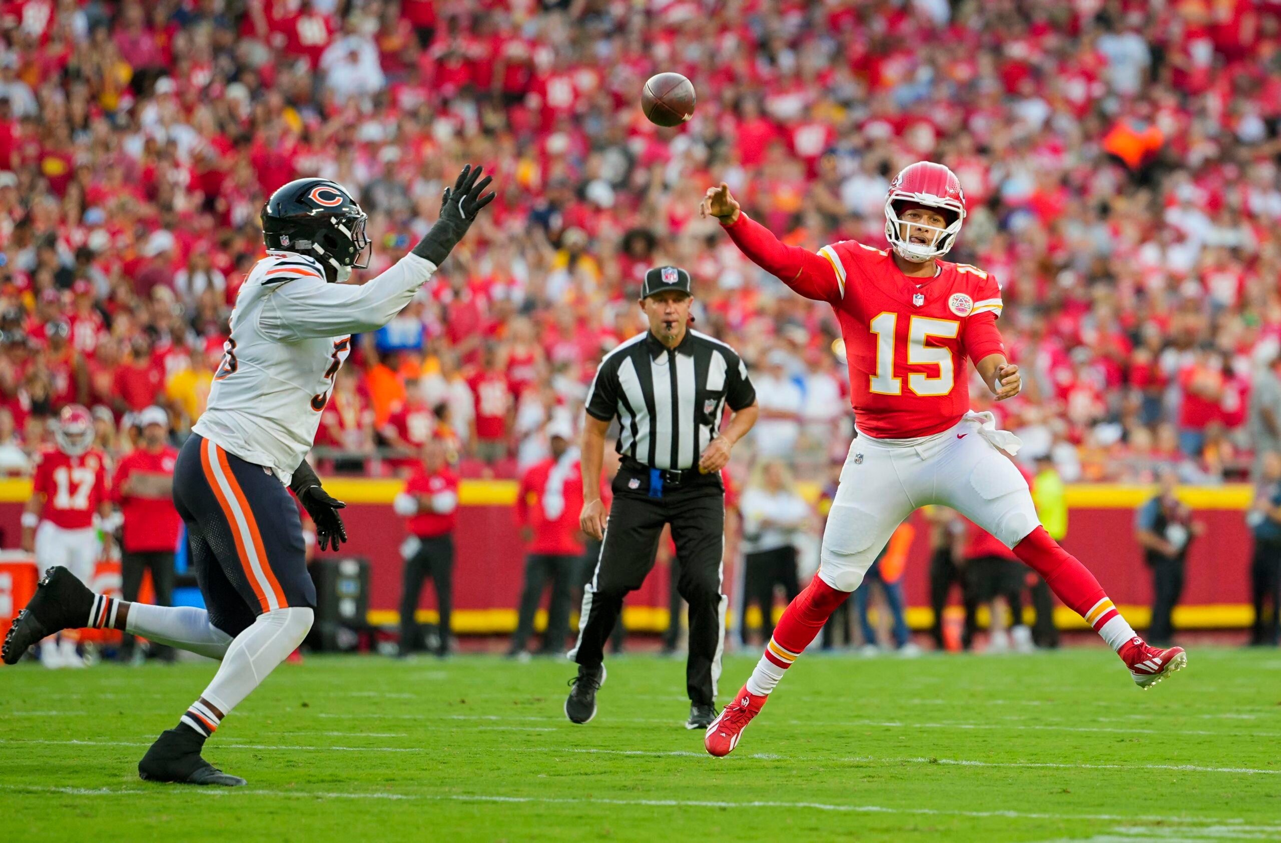 Aug 22, 2025; Kansas City, Missouri, USA; Kansas City Chiefs quarterback Patrick Mahomes (15) throws a pass against Chicago Bears defensive end Dayo Odeyingbo (55) during the first half at GEHA Field at Arrowhead Stadium.