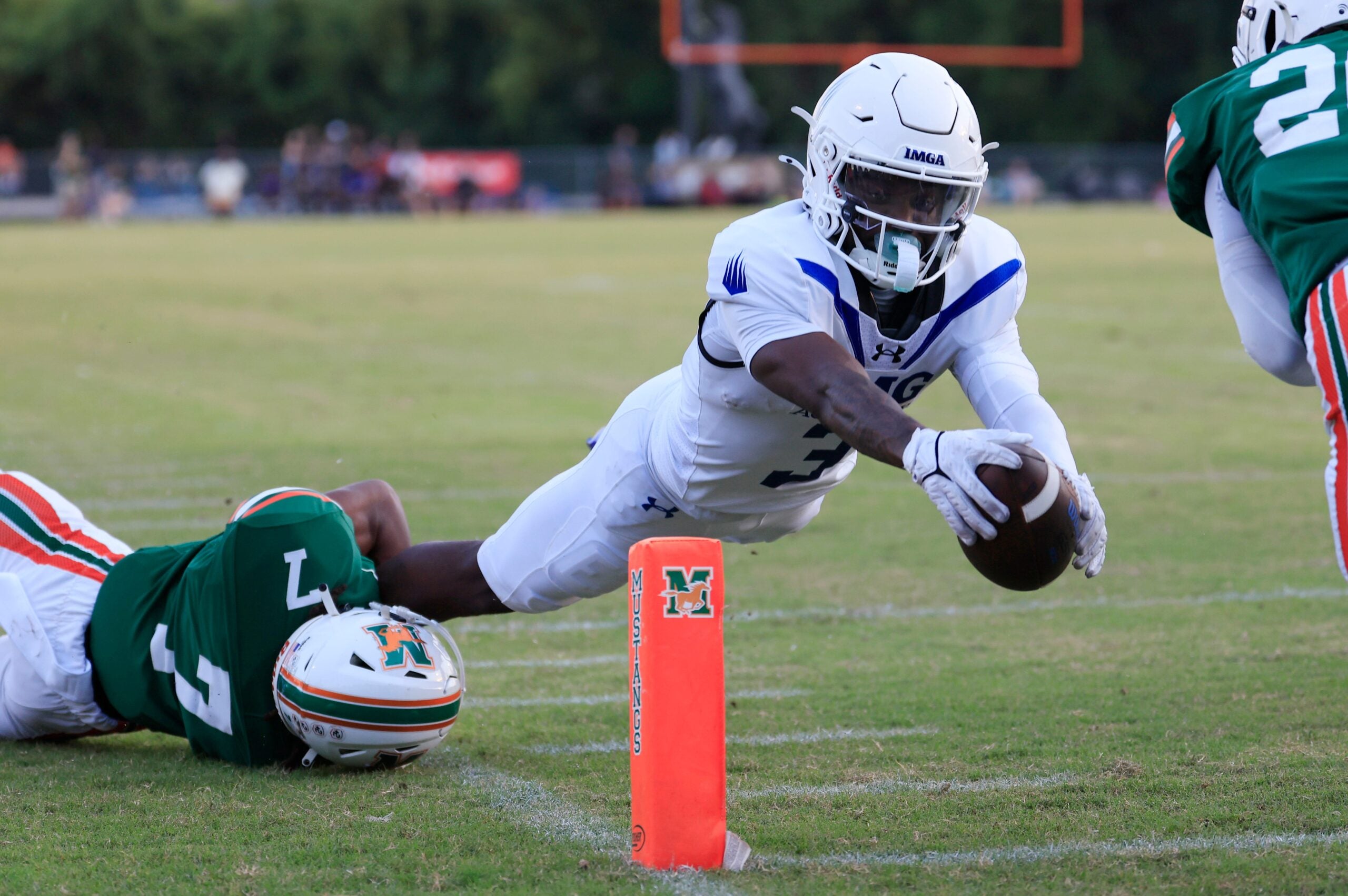 IMG Academy's Eric McFarland (3) scores a rushing touchdown against Mandarin's Tamajh Mitchell (7) during the first quarter of a high school football matchup at Mandarin High School, Friday, Sept. 19, 2025, in Jacksonville, Fla. The IMG Academy Ascenders defeated the Mandarin Mustangs 57-7.