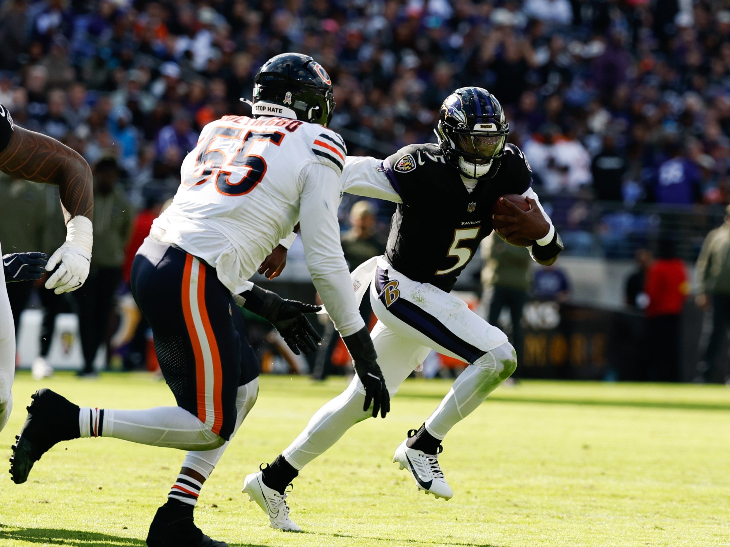 Oct 26, 2025; Baltimore, Maryland, USA; Baltimore Ravens quarterback Tyler Huntley (5) runs with the ball as Chicago Bears defensive end Dayo Odeyingbo (55) chases in the third quarter at M&T Bank Stadium.