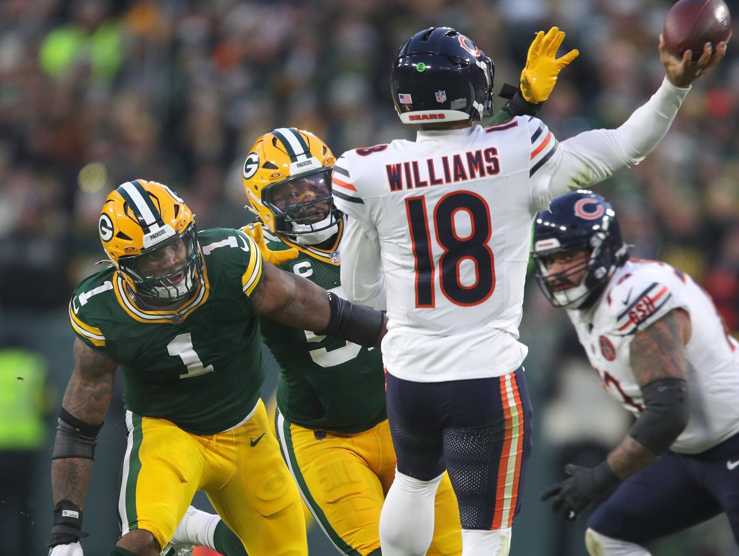 Green Bay Packers defensive end Micah Parsons (1) and defensive end Rashan Gary (52) pressure Chicago Bears quarterback Caleb Williams.