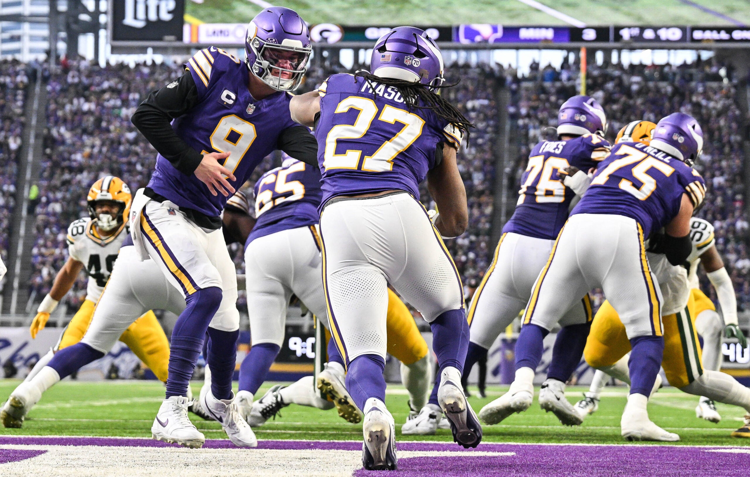 Jan 4, 2026; Minneapolis, Minnesota, USA; Minnesota Vikings quarterback J.J. McCarthy (9) hands the ball off to Minnesota Vikings running back Jordan Mason (27) against the Green Bay Packers during the first quarter at U.S. Bank Stadium.