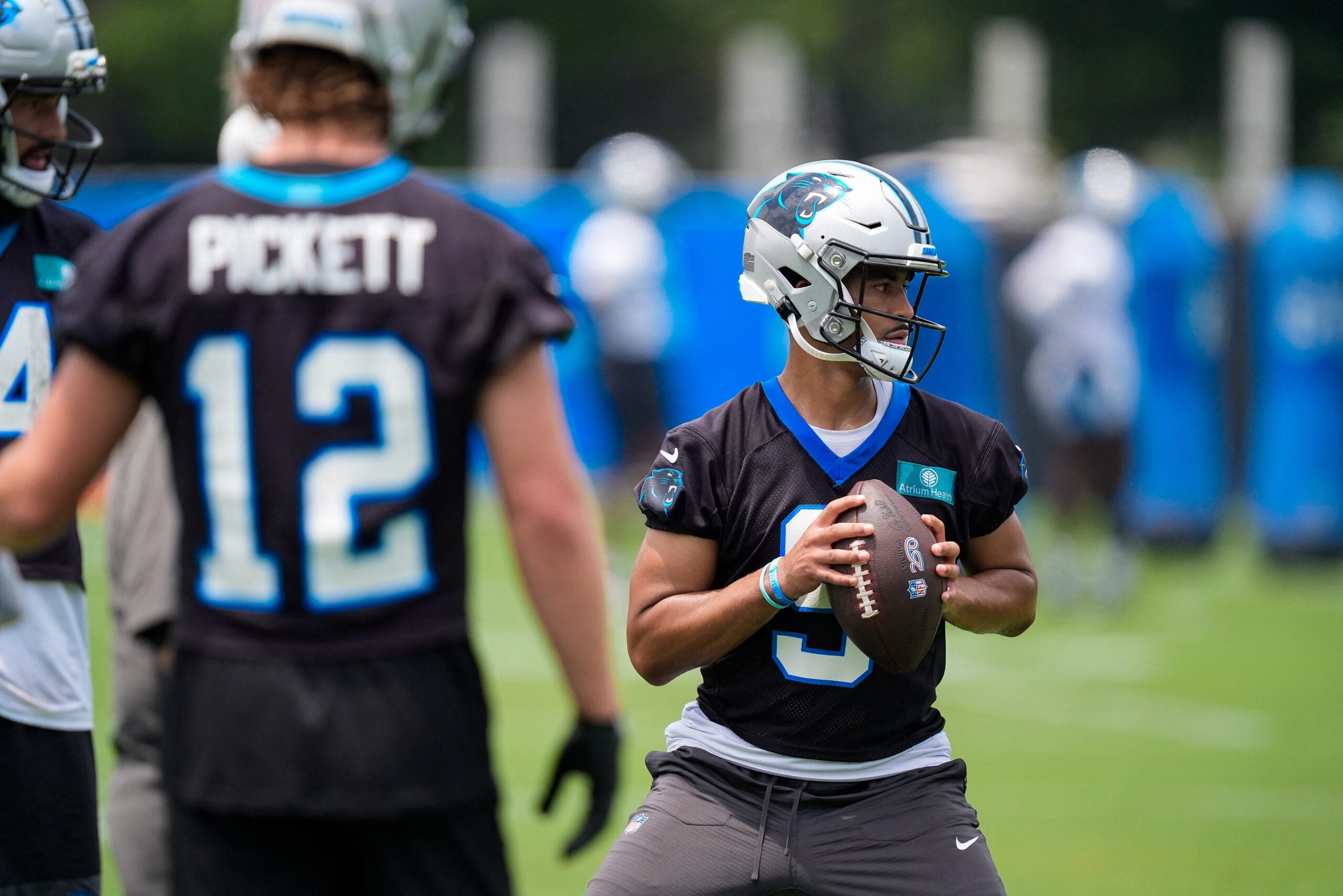 Jun 9, 2026; Charlotte, NC, USA; Carolina Panthers quarterback Will Grier (14) and quarterback Kenny Pickett (12) watch quarterback Bryce Young (9) during the first day of mini camp at Bank of America Stadium practice facility.