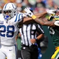 Indianapolis Colts running back Jonathan Taylor (28) stiff arms Green Bay Packers cornerback Jaire Alexander (23) on a first down run during their football game Sunday, September 15, 2024, at Lambeau Field in Green Bay, Wisconsin.