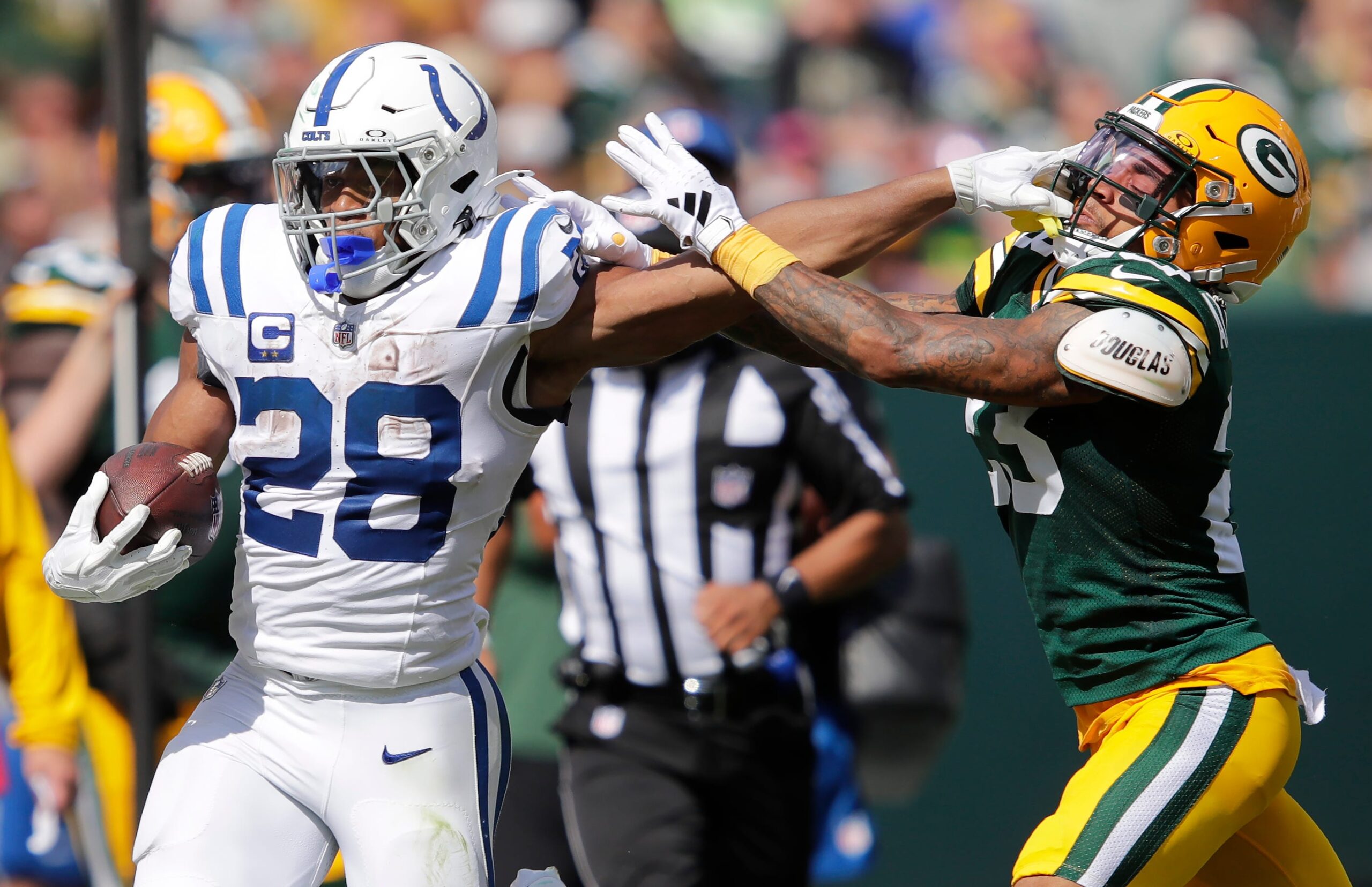 Indianapolis Colts running back Jonathan Taylor (28) stiff arms Green Bay Packers cornerback Jaire Alexander (23) on a first down run during their football game Sunday, September 15, 2024, at Lambeau Field in Green Bay, Wisconsin.