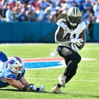 Sep 28, 2025; Orchard Park, New York, USA; New Orleans Saints running back Alvin Kamara (41) nearly fumbles after breaking a tackle by Buffalo Bills defensive end Joey Bosa (97) in the third quarter at Highmark Stadium.