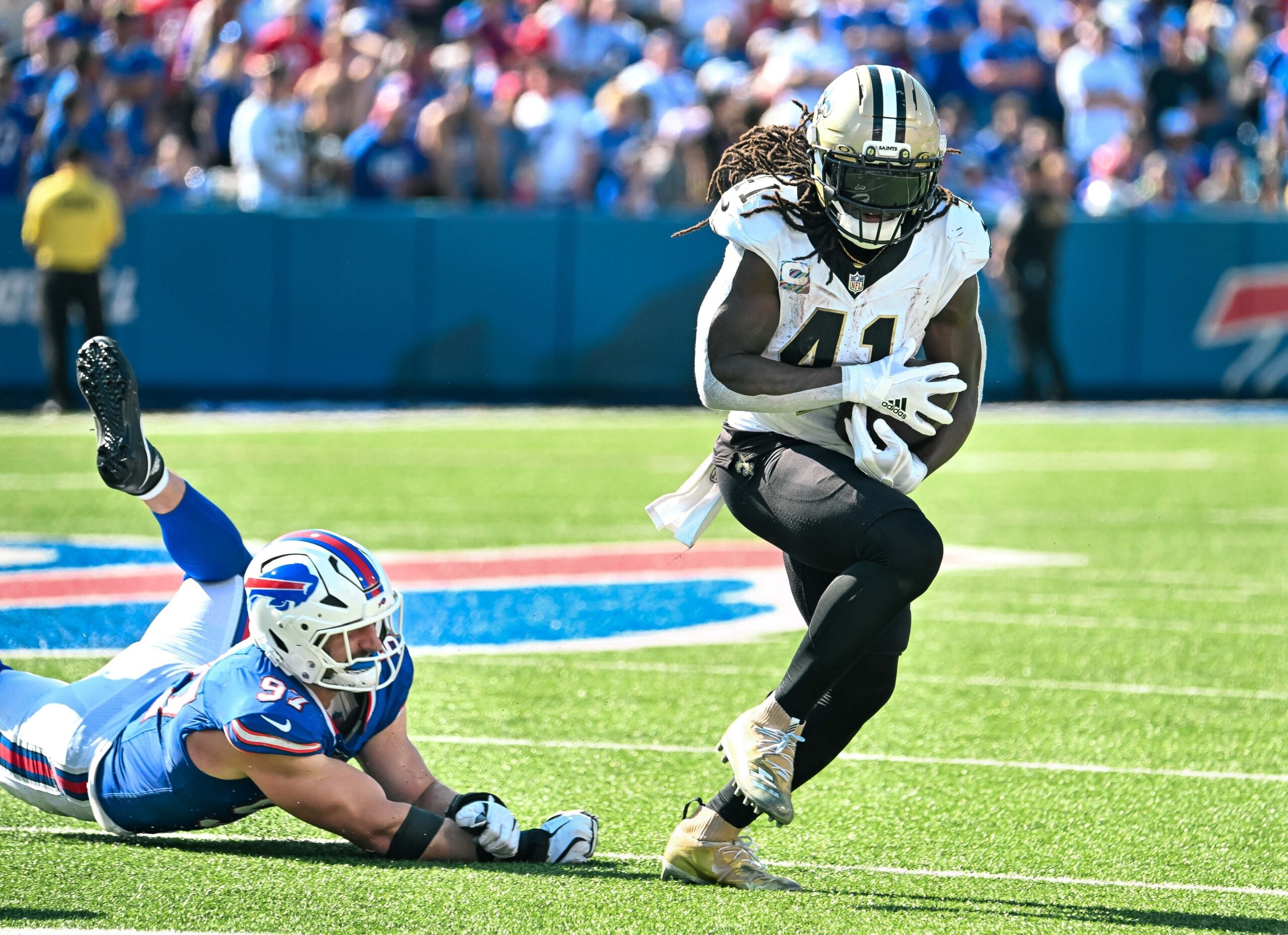Sep 28, 2025; Orchard Park, New York, USA; New Orleans Saints running back Alvin Kamara (41) nearly fumbles after breaking a tackle by Buffalo Bills defensive end Joey Bosa (97) in the third quarter at Highmark Stadium.