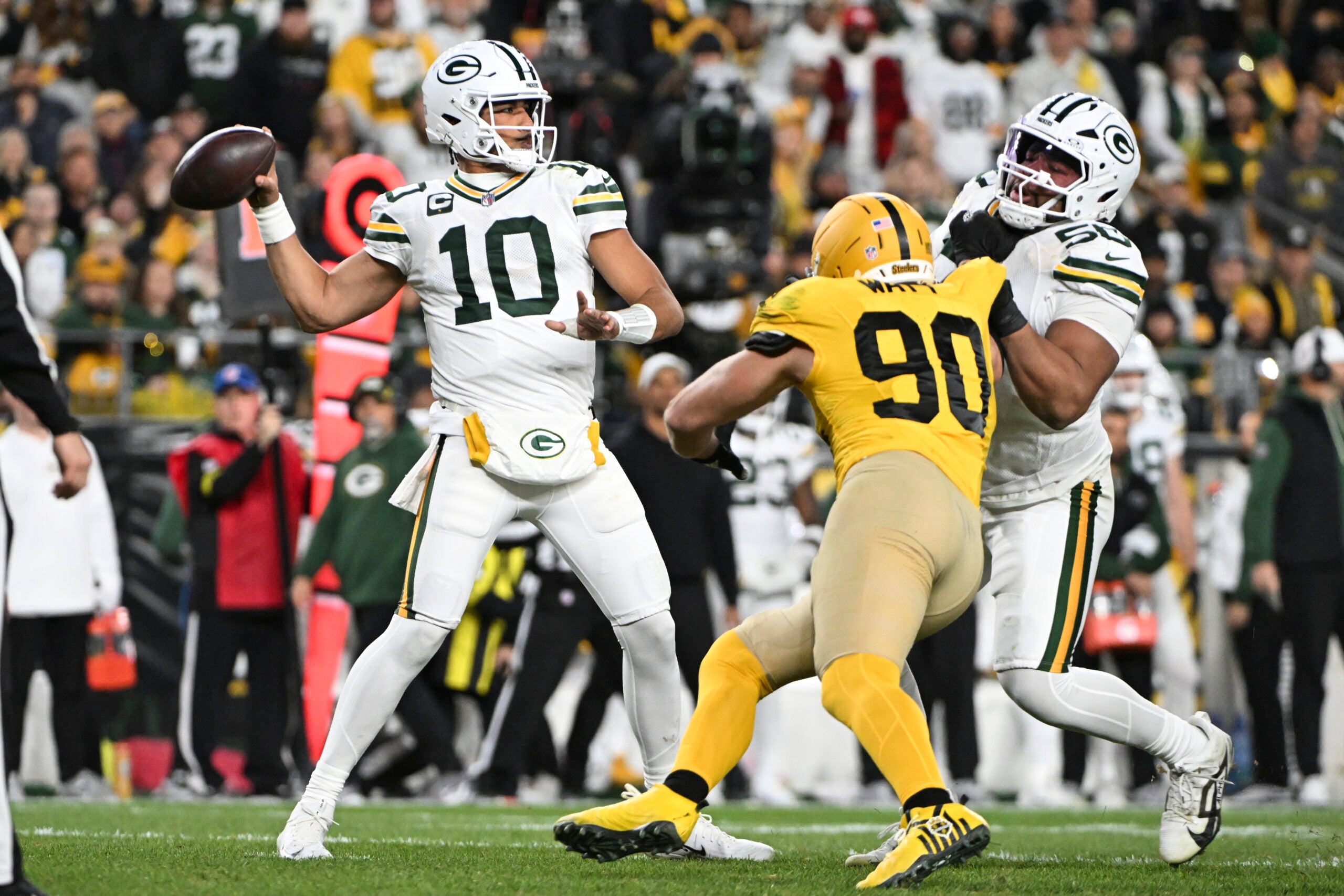 Oct 26, 2025; Pittsburgh, Pennsylvania, USA; Green Bay Packers quarterback Jordan Love (10) passes against Pittsburgh Steelers linebacker T.J. Watt (90) during the second quarter at Acrisure Stadium.