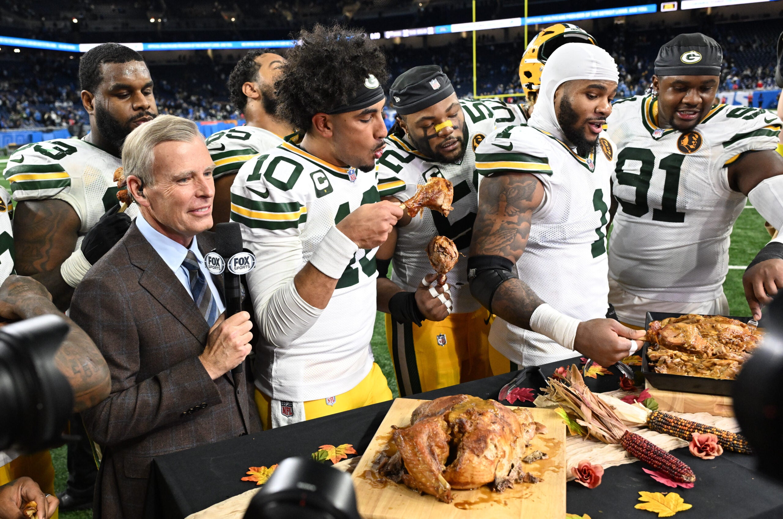 Nov 27, 2025; Detroit, Michigan, USA; Green Bay Packers quarterback Jordan Love (10), Green Bay Packers defensive end Micah Parsons (1) and Green Bay Packers defensive tackle Warren Brinson (91) eat turkey after defeating the Detroit Lions at Ford Field.