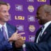 Dec 1, 2025; Baton Rouge, LA, USA; LSU new head coach Lane Kiffin, left, and LSU athletic director Verge Ausberry greet each other at South Stadium Club at Tiger Stadium.