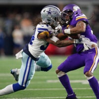 Dec 14, 2025; Arlington, Texas, USA; Dallas Cowboys cornerback Shavon Revel Jr. (34) tackles Minnesota Vikings running back Aaron Jones Sr. (33) during the first half at AT&T Stadium.