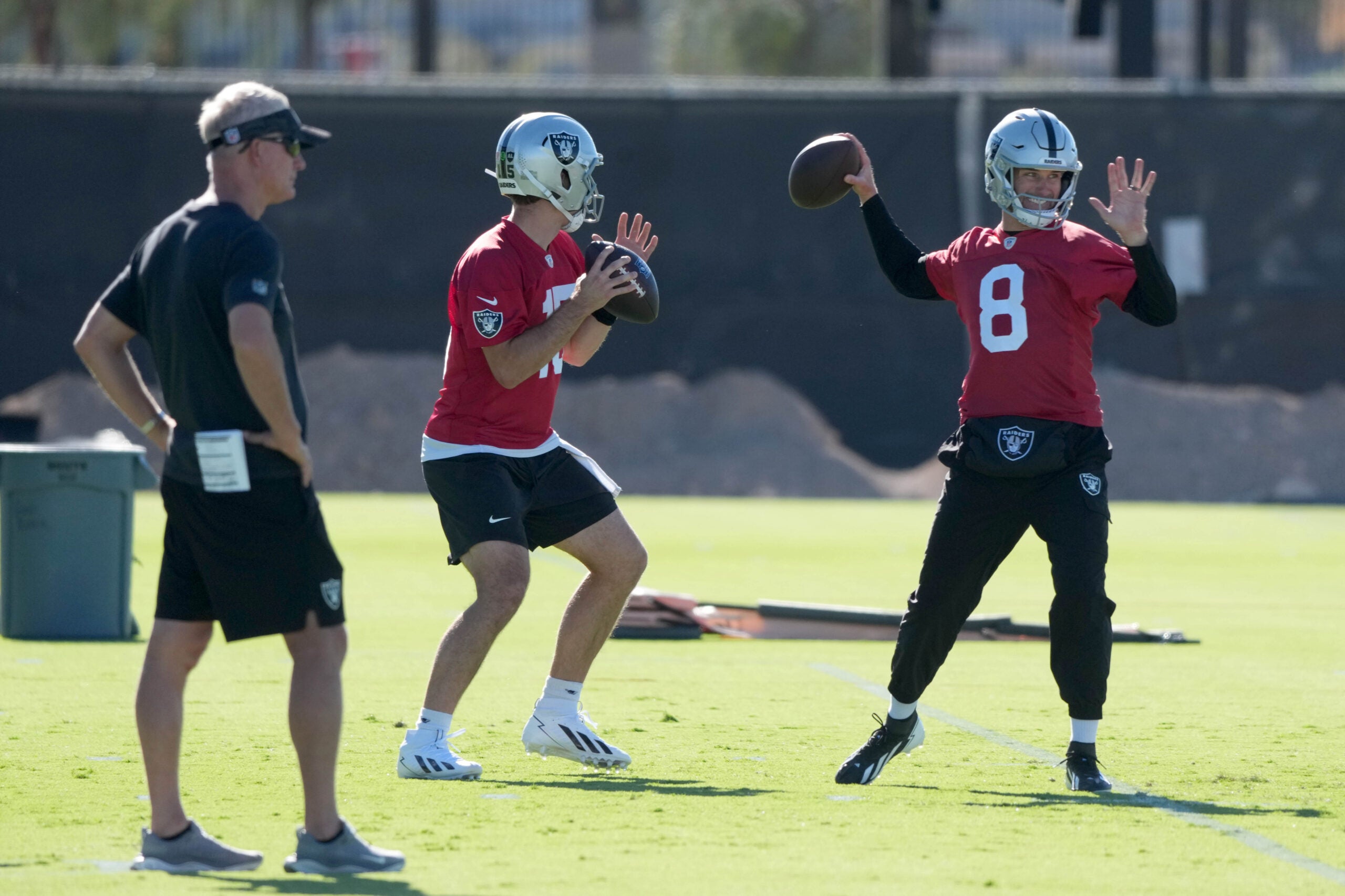 Jun 9, 2026; Henderson, NV, USA; Las Vegas Raiders quarterbacks Fernando Mendoza (15) and Kirk Cousins (8) throw the ball as assistant head coach Mike McCoy (left) watches during minicamp at Intermountain Health Performance Center.