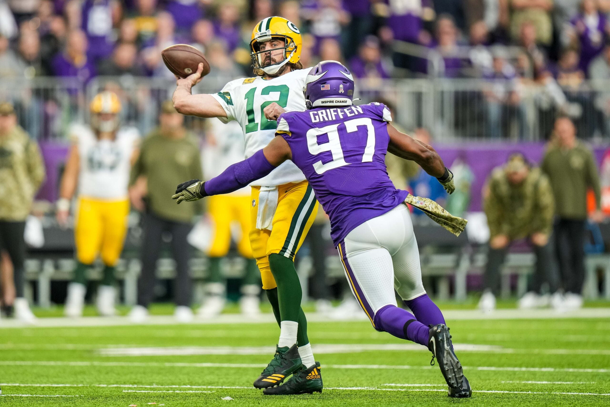 Nov 21, 2021; Minneapolis, Minnesota, USA; Green Bay Packers quarterback Aaron Rodgers (12) throws a touchdown pass in front of Minnesota Vikings defensive end Everson Griffen (97) during the fourth quarter at U.S. Bank Stadium.