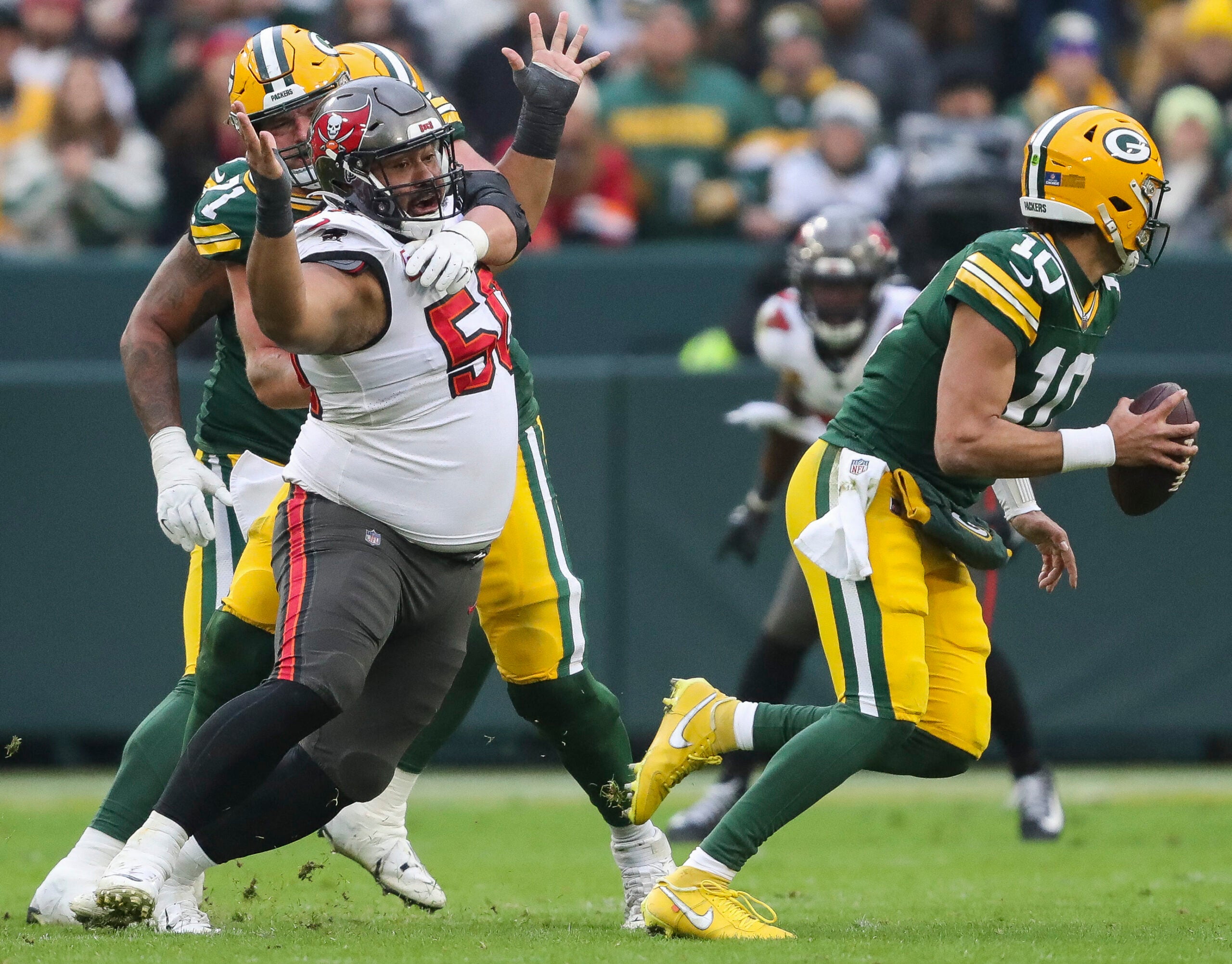 Dec 17, 2023; Green Bay, Wisconsin, USA; Tampa Bay Buccaneers defensive tackle Vita Vea (50) is held by Green Bay Packers center Josh Myers (71) as he rushes quarterback Jordan Love (10) at Lambeau Field.