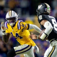 Nov 23, 2024; Baton Rouge, Louisiana, USA; LSU Tigers cornerback Zy Alexander (14) tackles Vanderbilt Commodores quarterback Nate Johnson (8) during the second half at Tiger Stadium.