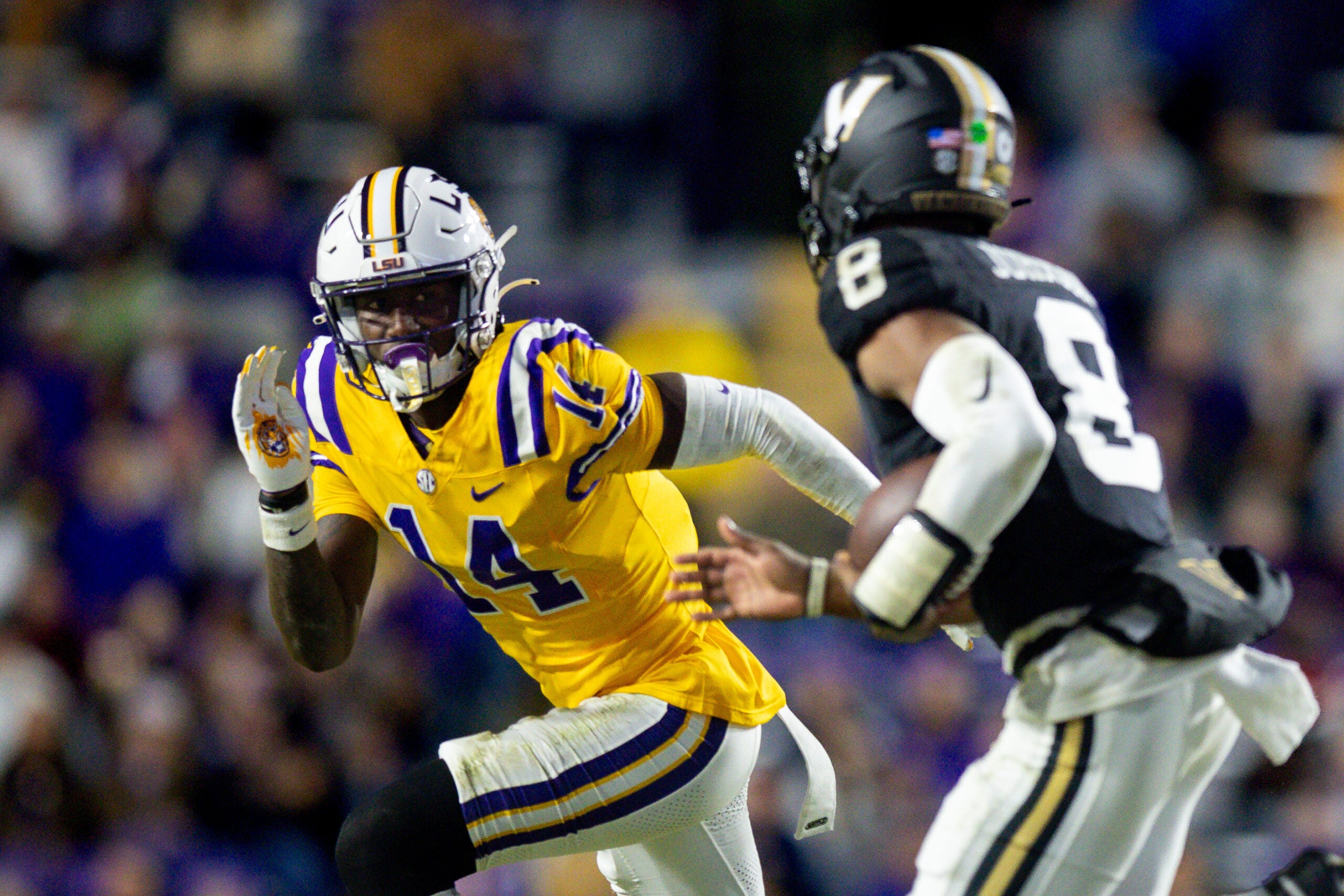 Nov 23, 2024; Baton Rouge, Louisiana, USA; LSU Tigers cornerback Zy Alexander (14) tackles Vanderbilt Commodores quarterback Nate Johnson (8) during the second half at Tiger Stadium.