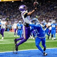 Minnesota Vikings wide receiver Justin Jefferson (18) makes a catch for a touchdown against Detroit Lions cornerback Amik Robertson (21) during the first half at Ford Field in Detroit on Sunday, November 2, 2025.