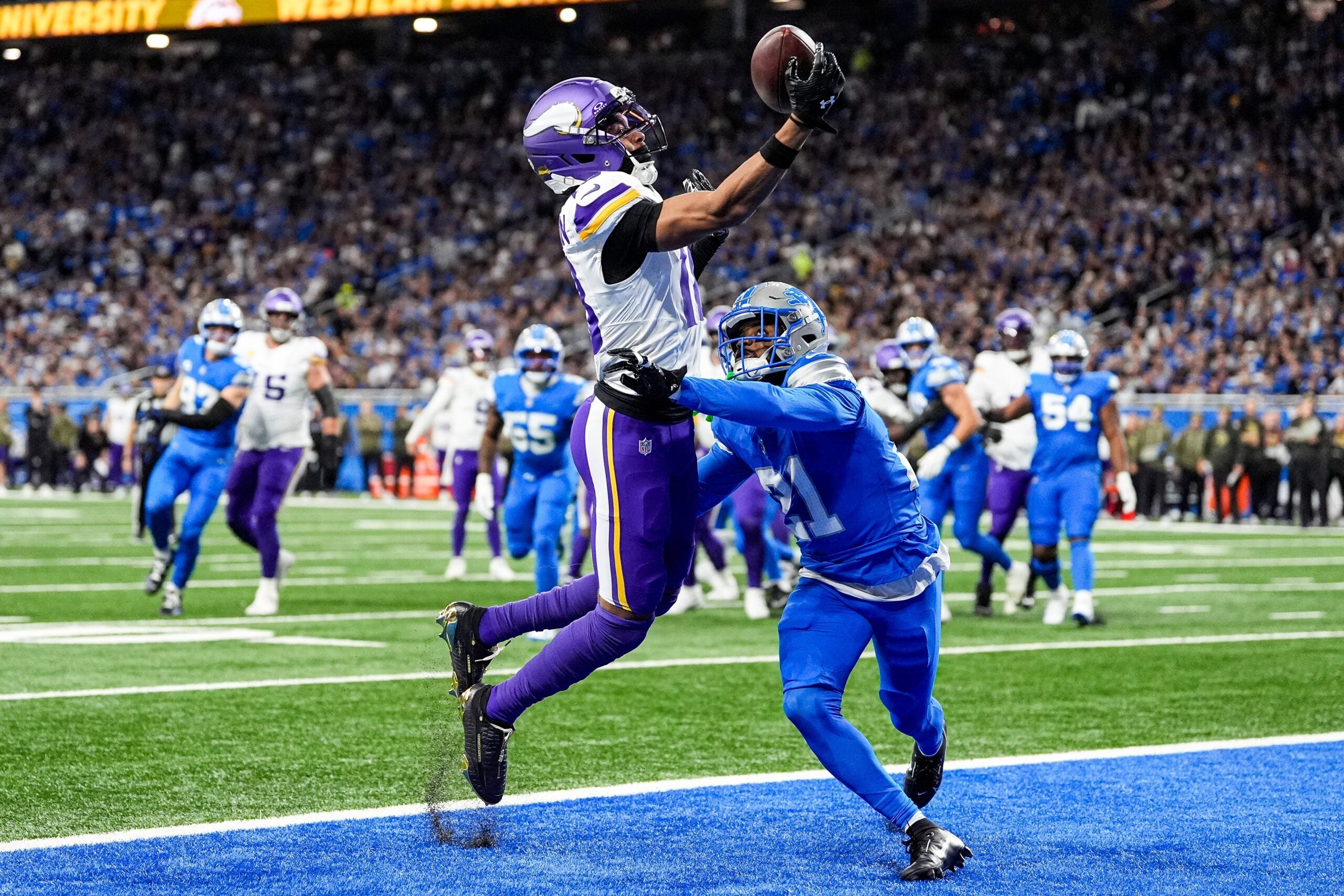Minnesota Vikings wide receiver Justin Jefferson (18) makes a catch for a touchdown against Detroit Lions cornerback Amik Robertson (21) during the first half at Ford Field in Detroit on Sunday, November 2, 2025.
