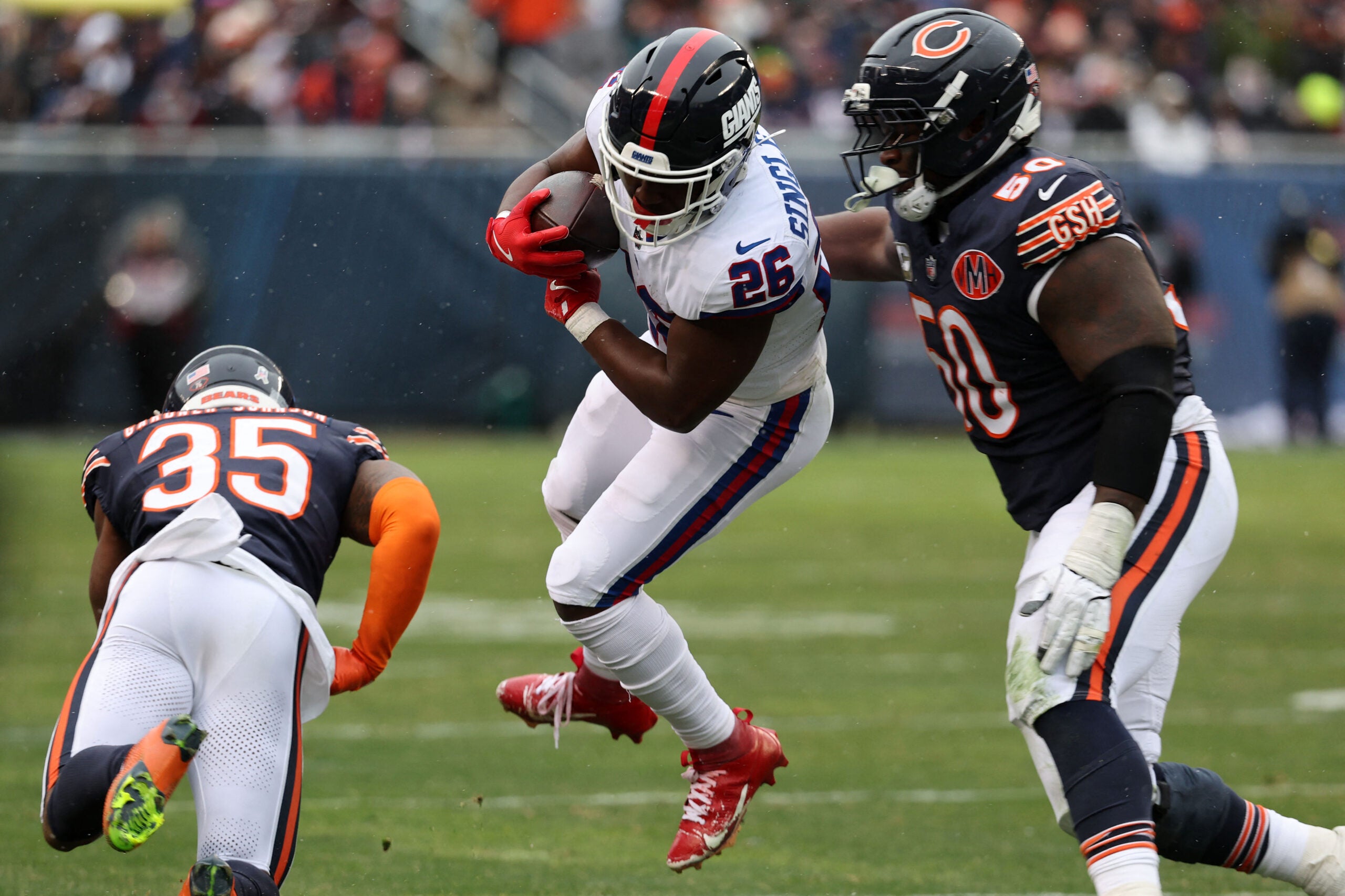 Nov 9, 2025; Chicago, Illinois, USA; New York Giants running back Devin Singletary (26) rushes the ball against Chicago Bears defensive tackle Grady Jarrett (50) during the second half at Soldier Field.