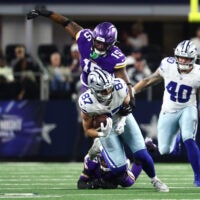Dec 14, 2025; Arlington, Texas, USA; Minnesota Vikings linebacker Dallas Turner (15) tackles Dallas Cowboys tight end Jake Ferguson (87) during the first half at AT&T Stadium.