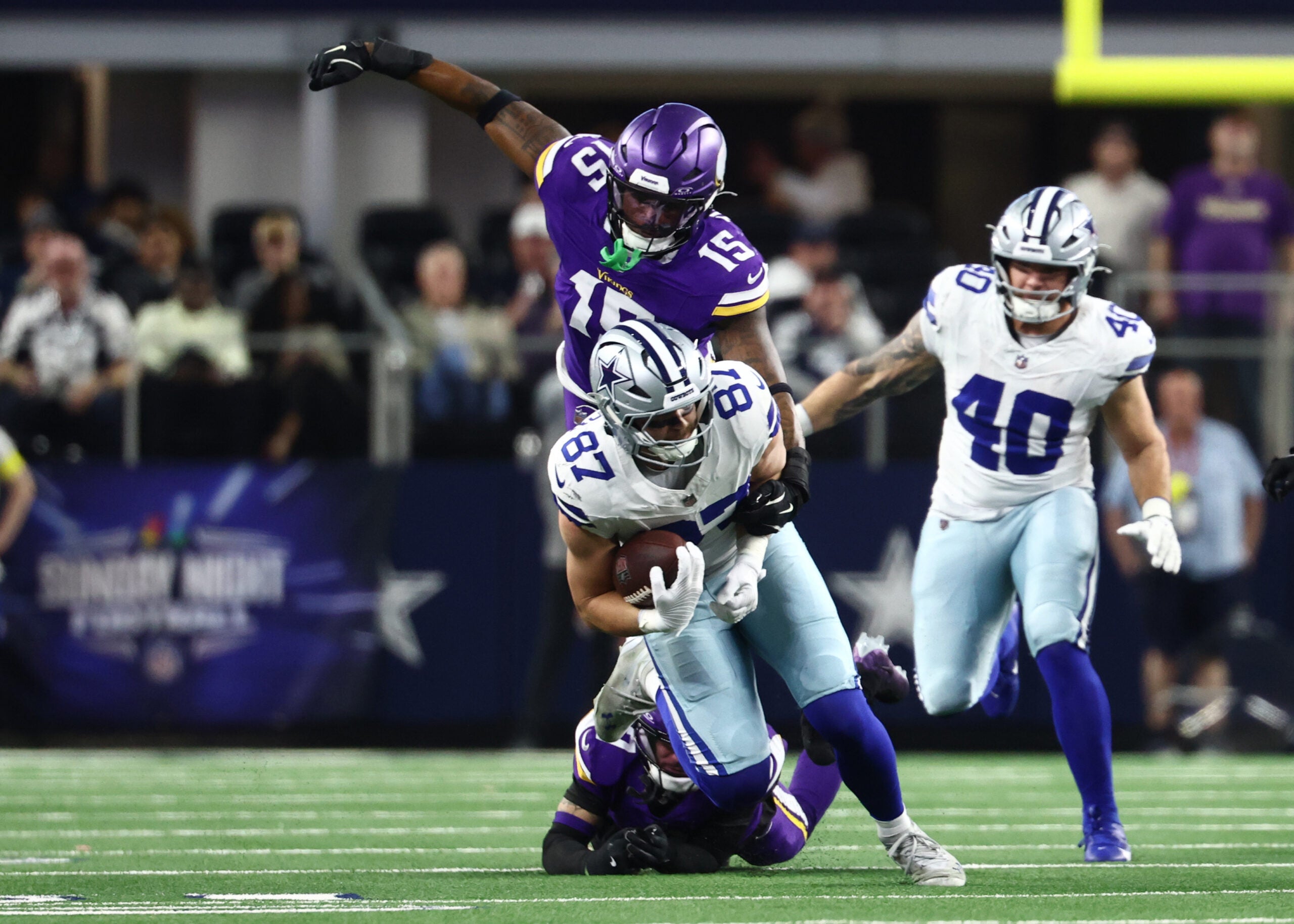 Dec 14, 2025; Arlington, Texas, USA; Minnesota Vikings linebacker Dallas Turner (15) tackles Dallas Cowboys tight end Jake Ferguson (87) during the first half at AT&T Stadium.