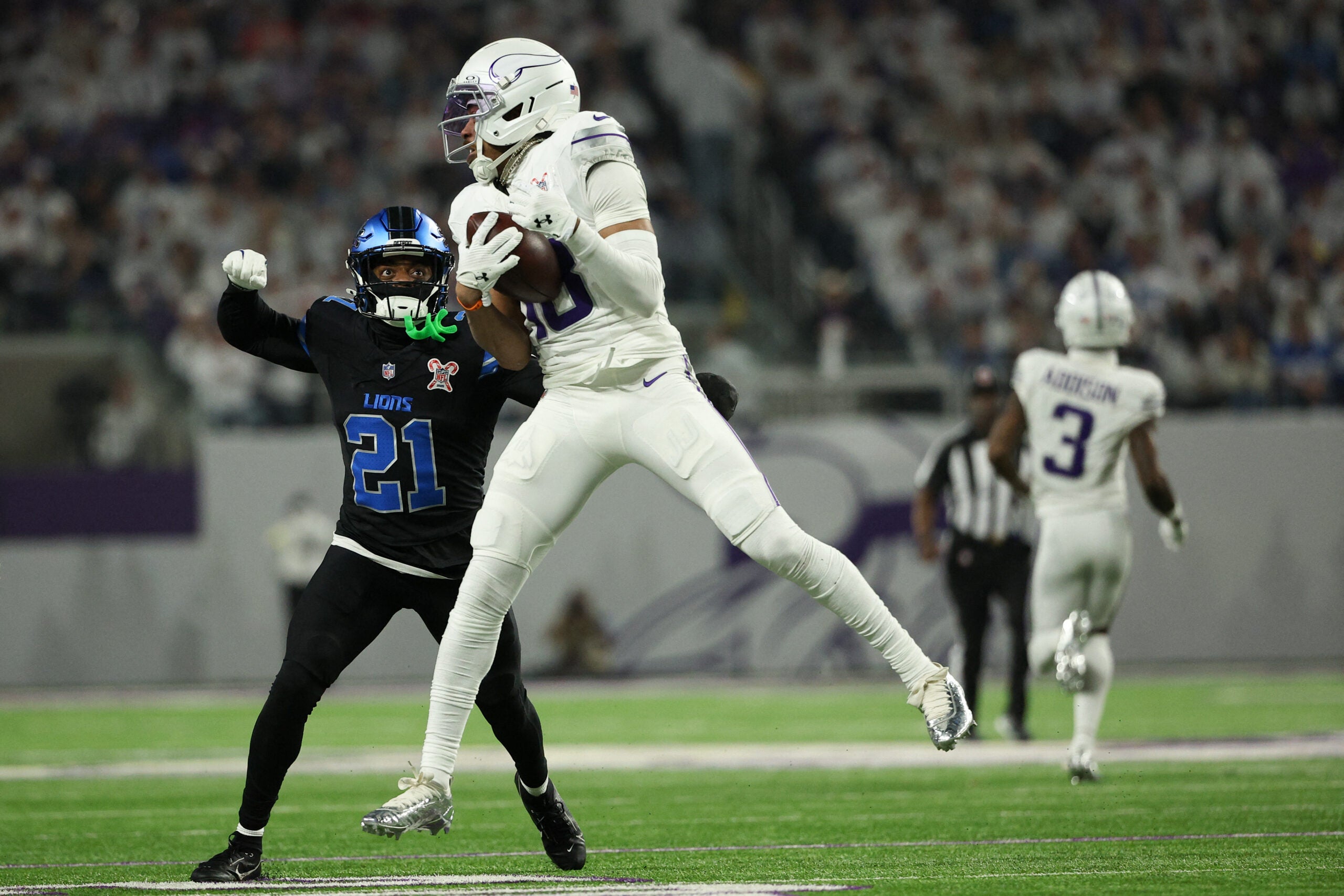 Dec 25, 2025; Minneapolis, Minnesota, USA; Minnesota Vikings wide receiver Justin Jefferson (18) makes a catch defended by Detroit Lions cornerback Amik Robertson (21) in the third quarter at U.S. Bank Stadium.