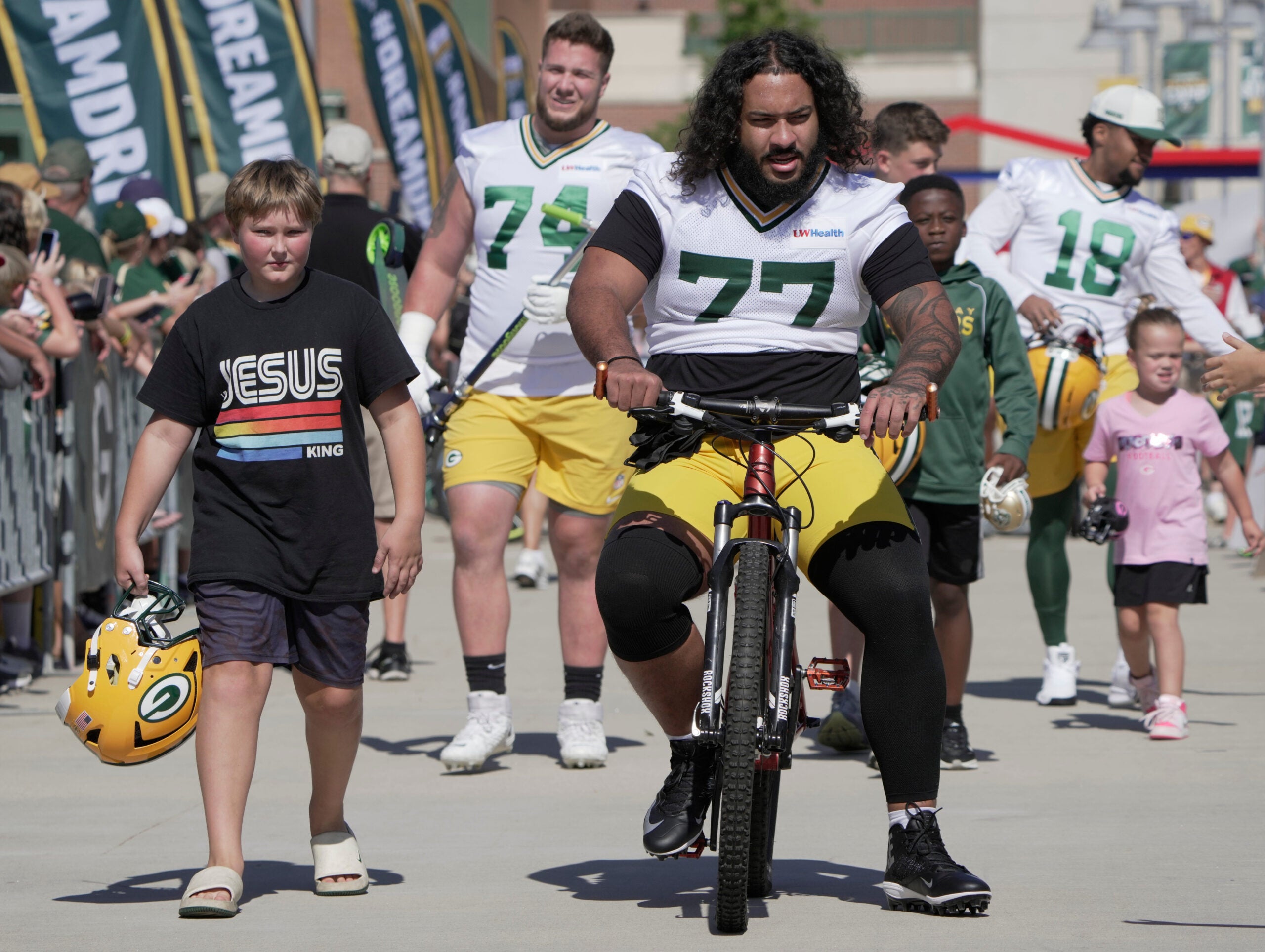 Green Bay Packers offensive tackle Jordan Morgan (77) rides a bike during the first day of training camp Wednesday, July 29, 2026 in Green Bay, Wisconsin. It is the first of three consecutive public practices. The tradition of players riding childrens bikes to practice dates back to the era when Vince Lombardi was head coach.