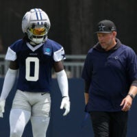 Jul 29, 2026; Oxnard, CA, USA; Dallas Cowboys linebacker DeMarvion Overshown (0) talks with inside linebackers coach Scott Symons at training camp at River Ridge Playing Fields.