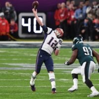 Feb 4, 2018; Minneapolis, MN, USA; New England Patriots quarterback Tom Brady (12) attempts to throw a touchdown during the final seconds of the fourth quarter as Philadelphia Eagles defensive tackle Fletcher Cox (91) defends in Super Bowl LII at U.S. Bank Stadium.