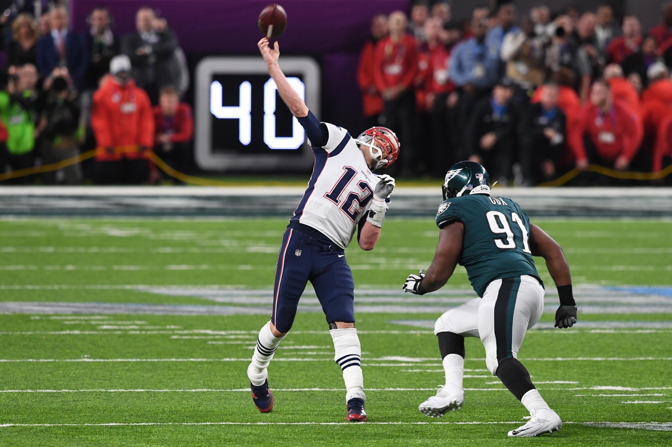 Feb 4, 2018; Minneapolis, MN, USA; New England Patriots quarterback Tom Brady (12) attempts to throw a touchdown during the final seconds of the fourth quarter as Philadelphia Eagles defensive tackle Fletcher Cox (91) defends in Super Bowl LII at U.S. Bank Stadium.