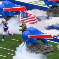 Nov 24, 2019; Orchard Park, NY, USA; Buffalo Bills quarterback Josh Allen (17) jogs on the field during player introductions while being escorted by a member of the military carrying an American Flag prior to the game against the Denver Broncos at New Era Field.