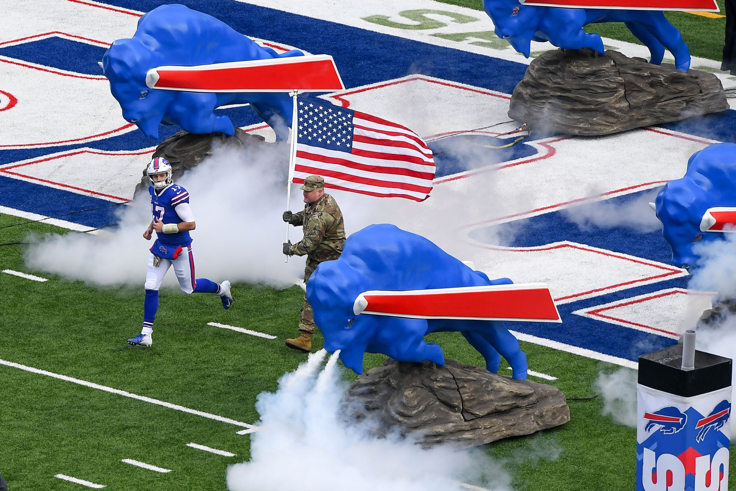Nov 24, 2019; Orchard Park, NY, USA; Buffalo Bills quarterback Josh Allen (17) jogs on the field during player introductions while being escorted by a member of the military carrying an American Flag prior to the game against the Denver Broncos at New Era Field.
