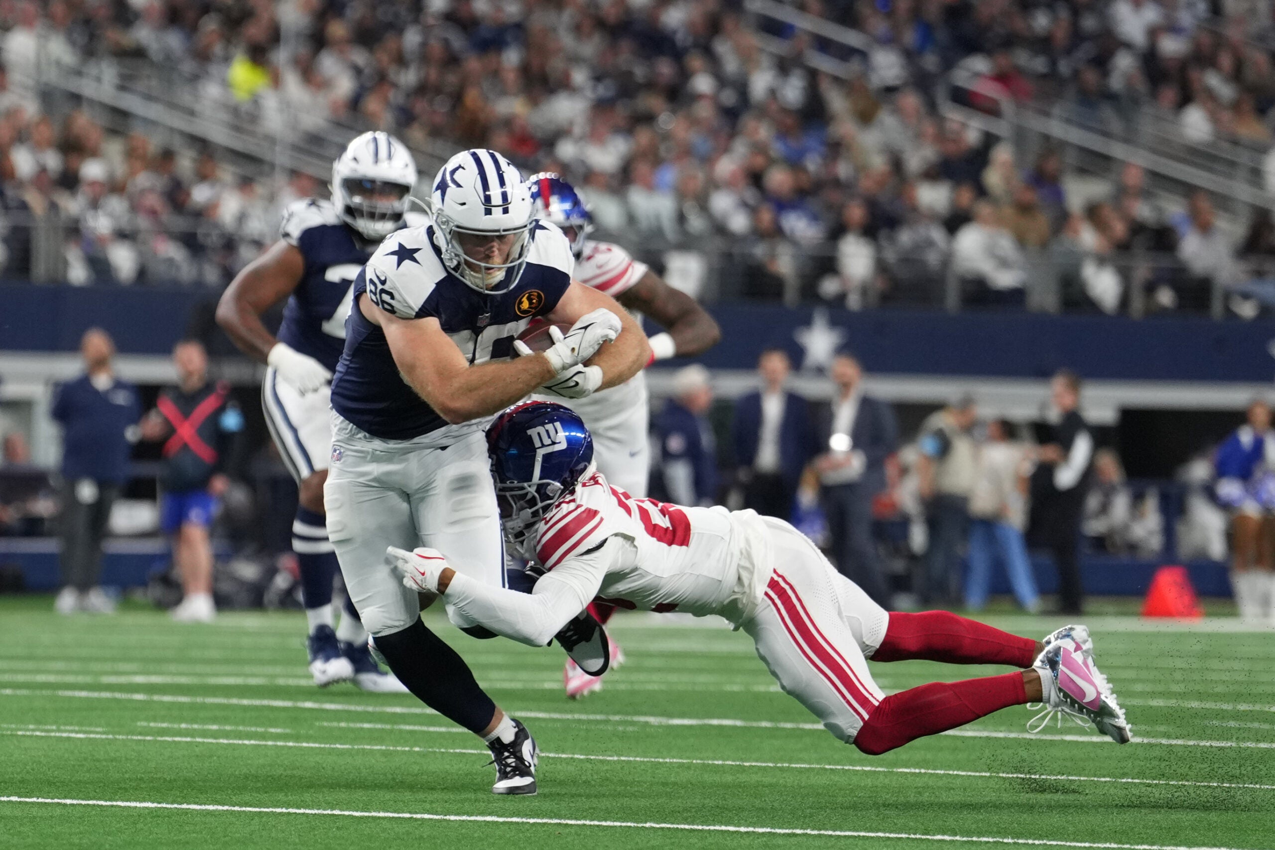 Nov 28, 2024; Arlington, Texas, USA; Dallas Cowboys tight end Luke Schoonmaker (86) catches a pass as New York Giants cornerback Cor'Dale Flott (28) defends during the first half at AT&T Stadium.