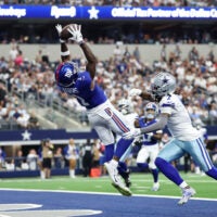 Sep 14, 2025; Arlington, Texas, USA; New York Giants wide receiver Malik Nabers (1) makes a catch for a touchdown against Dallas Cowboys cornerback Trevon Diggs (7) during the second quarter at AT&T Stadium.