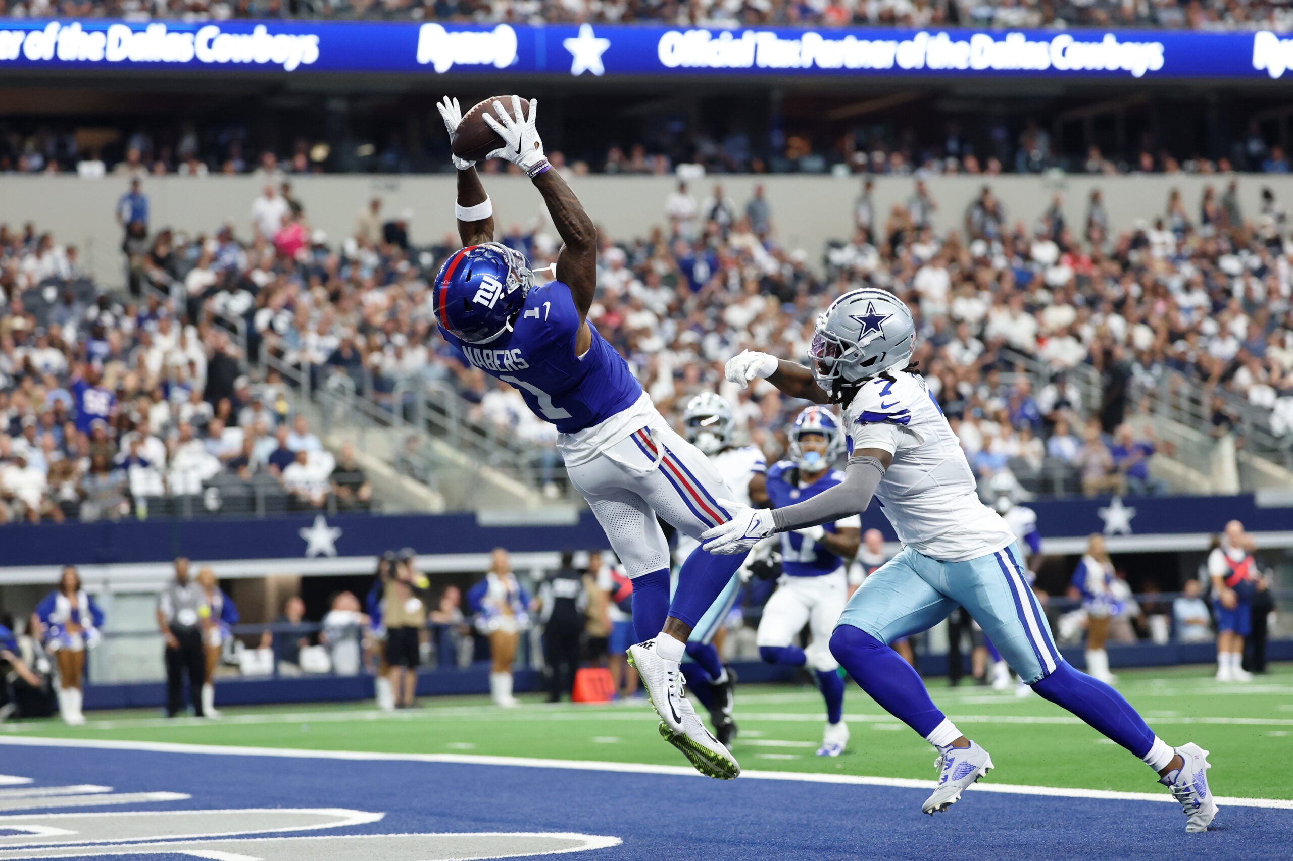 Sep 14, 2025; Arlington, Texas, USA; New York Giants wide receiver Malik Nabers (1) makes a catch for a touchdown against Dallas Cowboys cornerback Trevon Diggs (7) during the second quarter at AT&T Stadium.