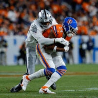 Nov 6, 2025; Denver, Colorado, USA; Denver Broncos wide receiver Courtland Sutton (14) is tackled by Las Vegas Raiders defensive end Charles Snowden (49) in the fourth quarter at Empower Field at Mile High.