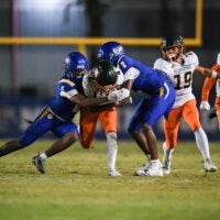 Martin County's Amarion Queen (2) and Jeromie King (5) tackle McArthur's Jaylyn Jones (4) in a Region 4-5A quarterfinal football game, Nov. 14, 2025, at Martin County High School. McArthur won 41-13.