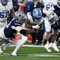Dec 4, 2025; Detroit, Michigan, USA; Detroit Lions running back Jahmyr Gibbs (0) is tackled by Dallas Cowboys defensive tackle Quinnen Williams (92) during the first half at Ford Field.
