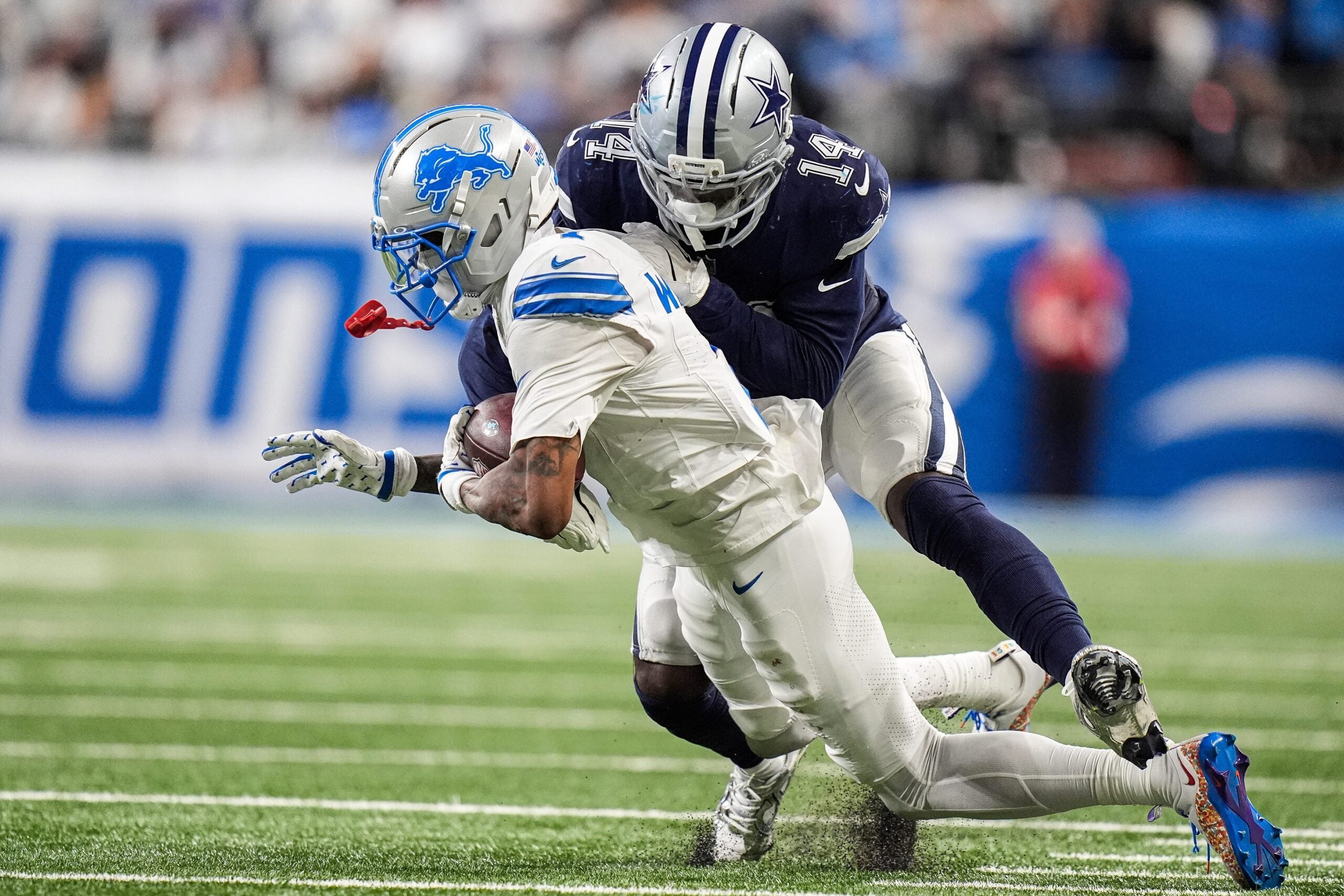 Detroit Lions wide receiver Jameson Williams (1) makes a catch against Dallas Cowboys safety Markquese Bell (14) during the second half at Ford Field in Detroit on Thursday, Dec. 4, 2025.
