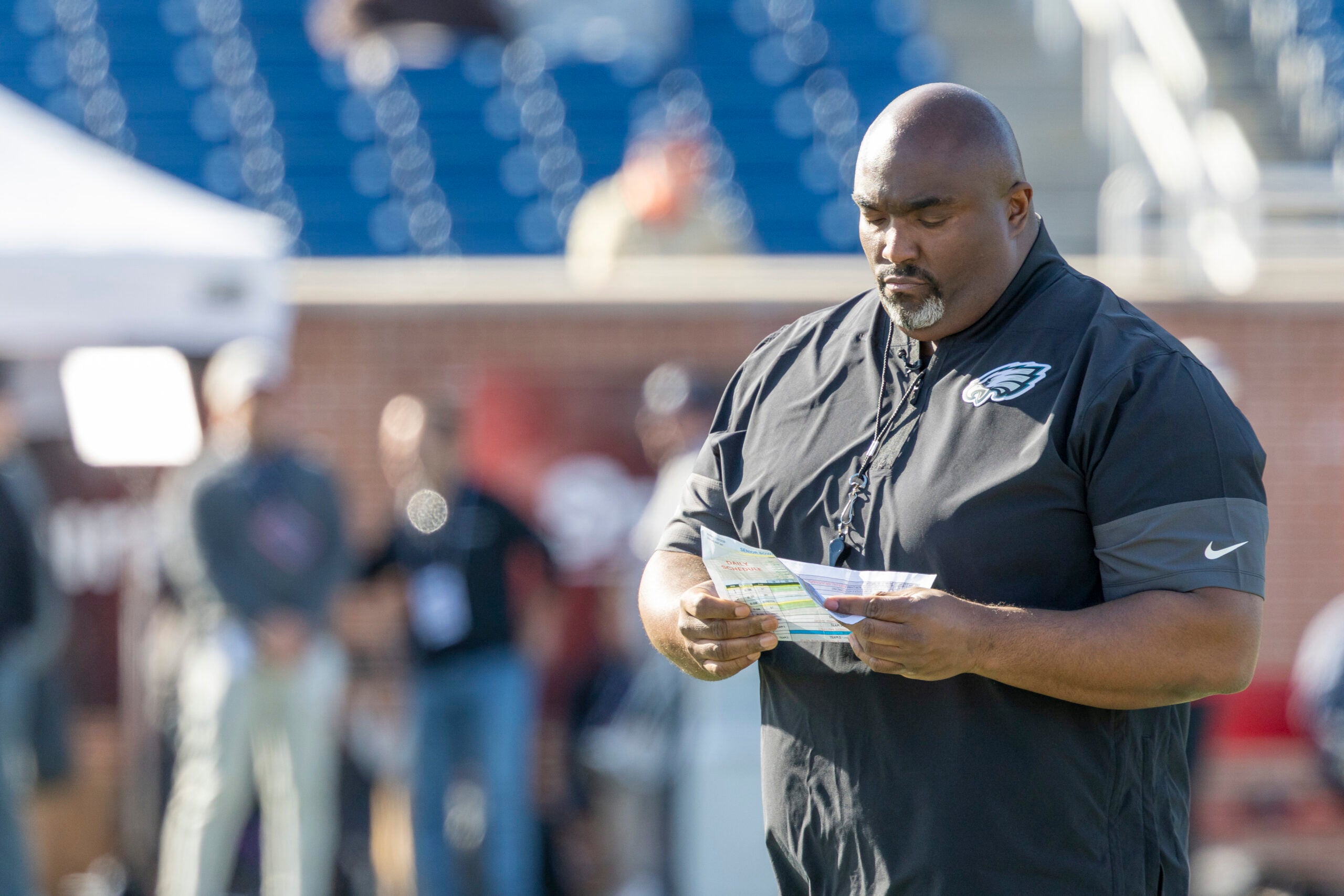 Jan 29, 2026; Mobile, AL, USA; National Team head coach Clint Hurtt of the Philadelphia Eagles checks his notes during National Senior Bowl practice at Hancock Whitney Stadium.