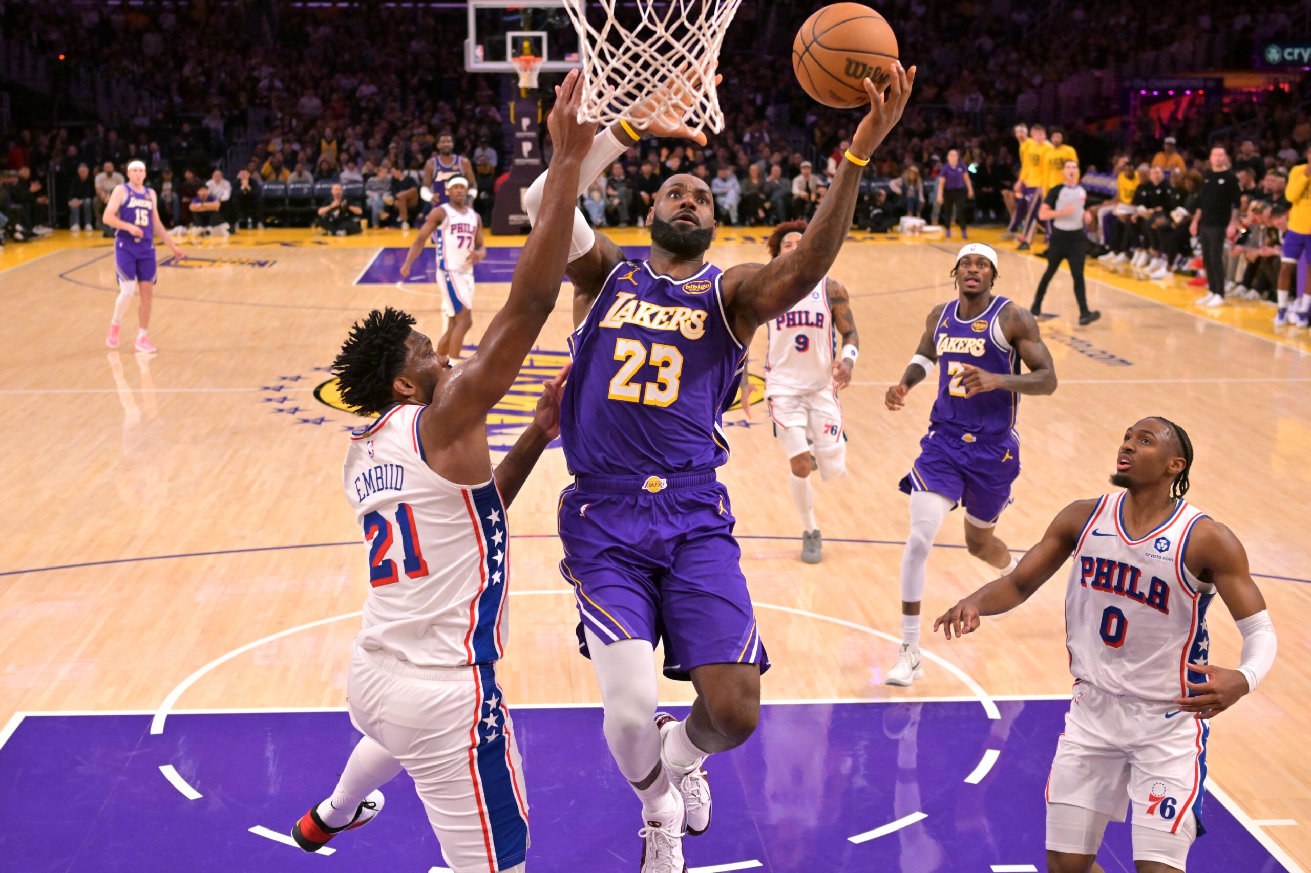 Feb 5, 2026; Los Angeles, California, USA; Los Angeles Lakers forward LeBron James (23) drives past Philadelphia 76ers center Joel Embiid (21) in the second half at Crypto.com Arena.